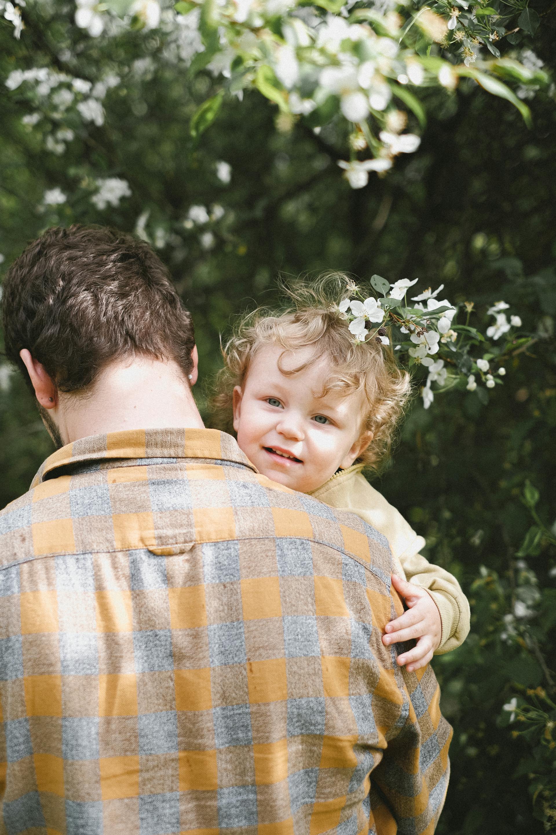 Un hombre llevando a su hijo | Fuente: Pexels