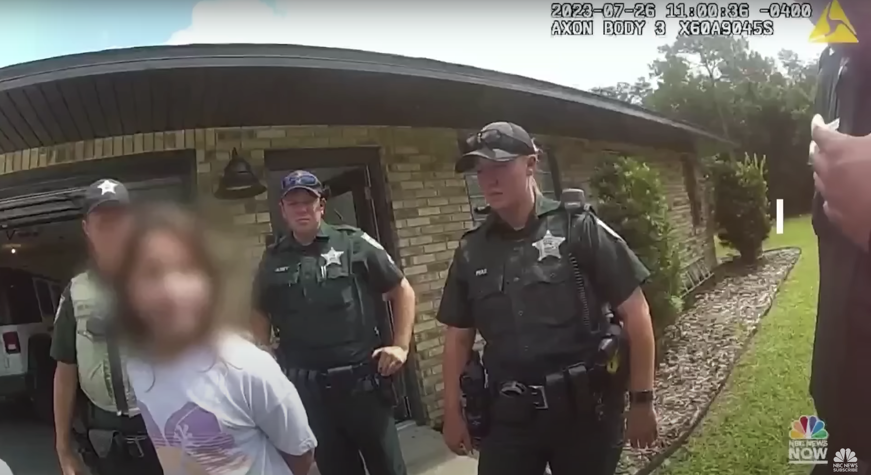 Agentes de policía aparecen de pie detrás tras esposar a una niña de 11 años de Florida frente a su casa. | Foto: youtube.com/NBC News