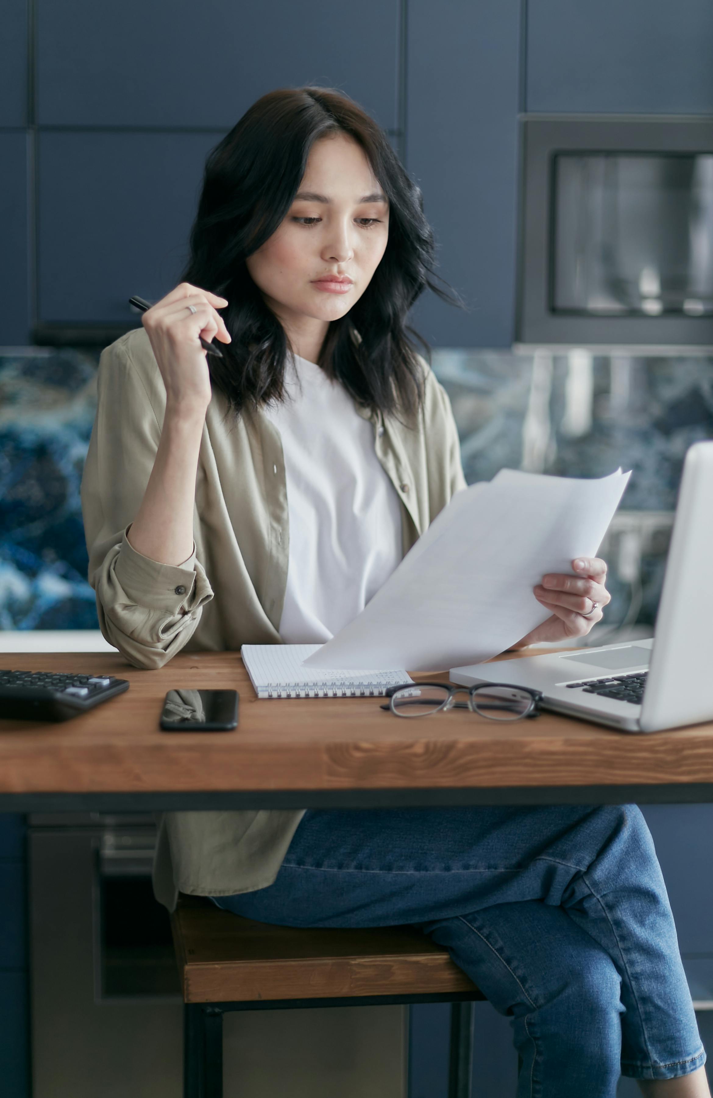 Mujer firmando documentos | Fuente: Pexels