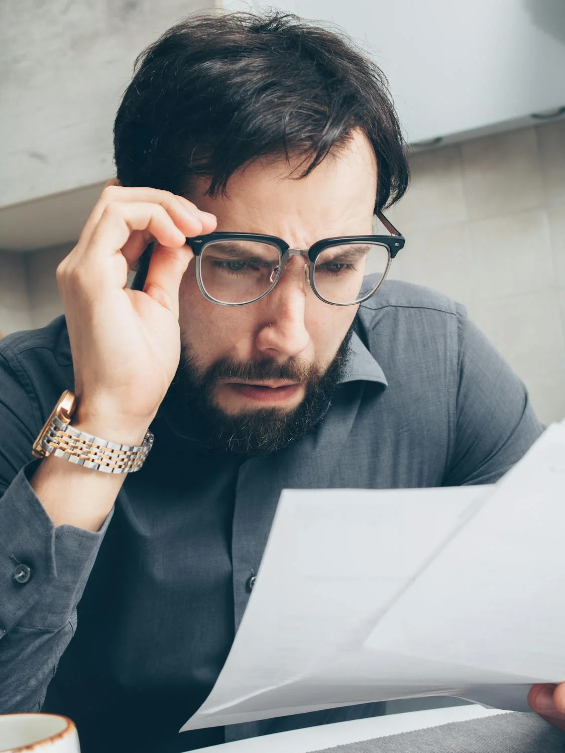 Un hombre conmocionado mirando los papeles | Fuente: Pexels