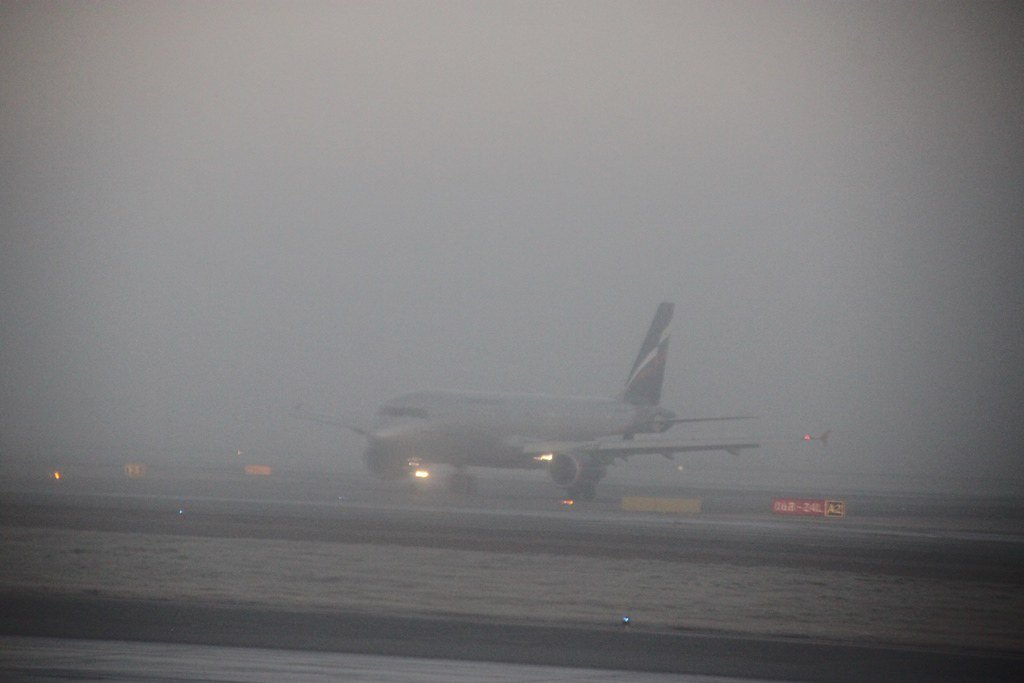 Avión sobre una pista con mucha neblina. | Foto: Flickr