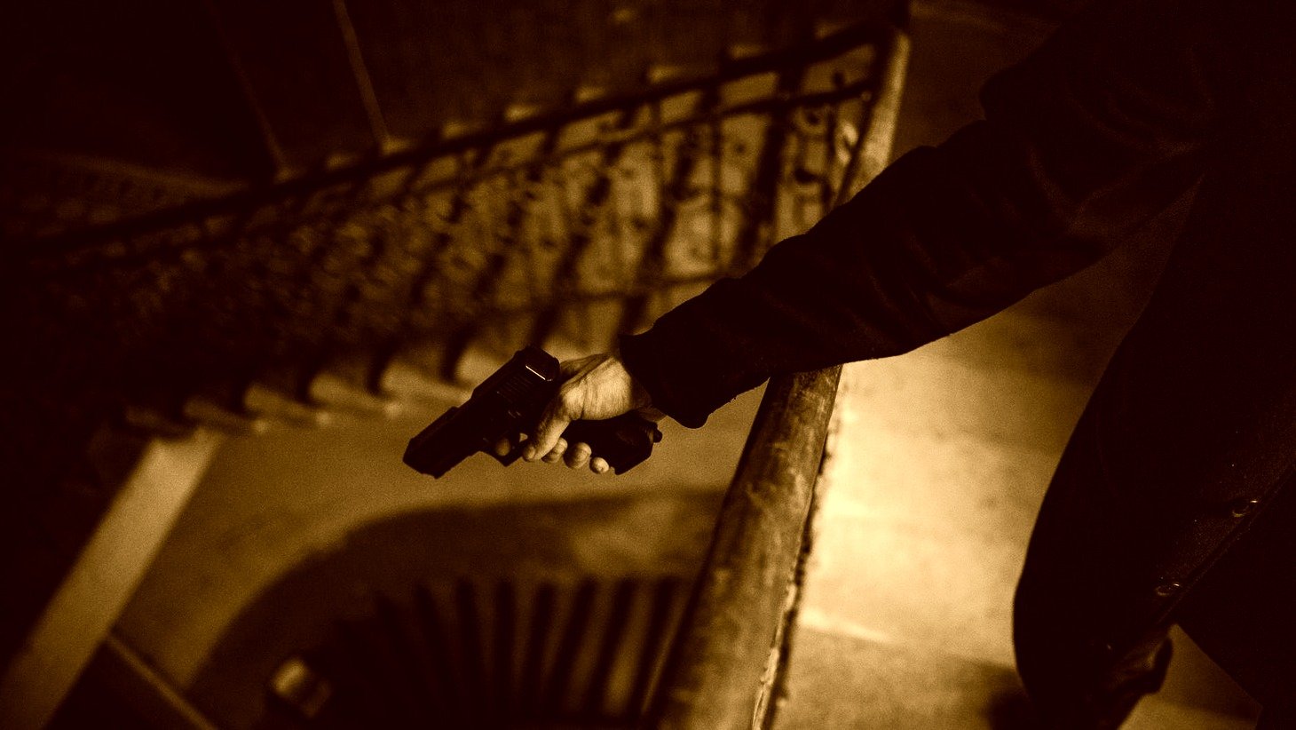 Persona con un arma en su mano, apunta hacia una escalera. | Foto: Pexels