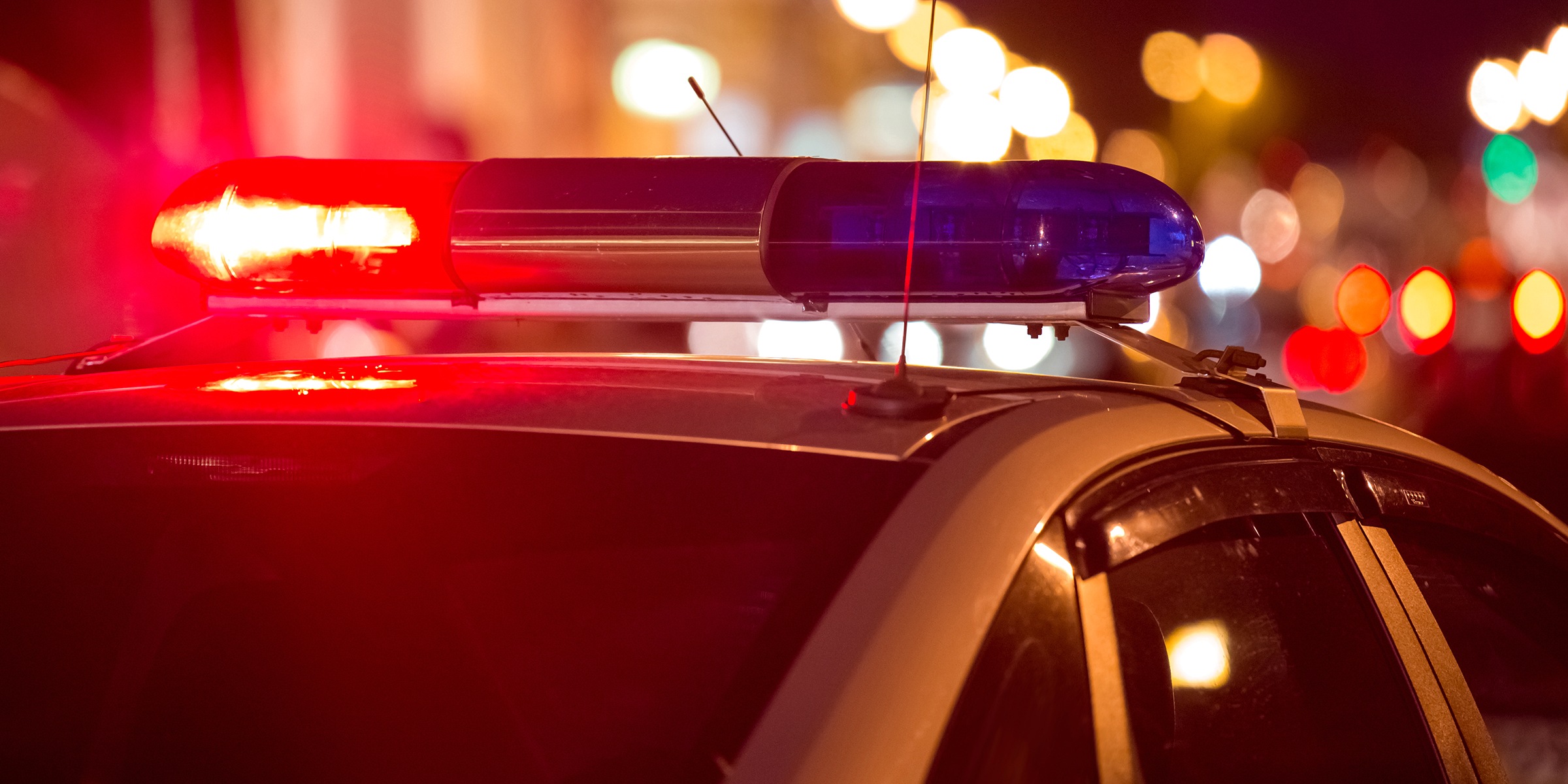 Un automóvil de policía con luces intermitentes rojas y azules por la noche | Fuente: Shutterstock