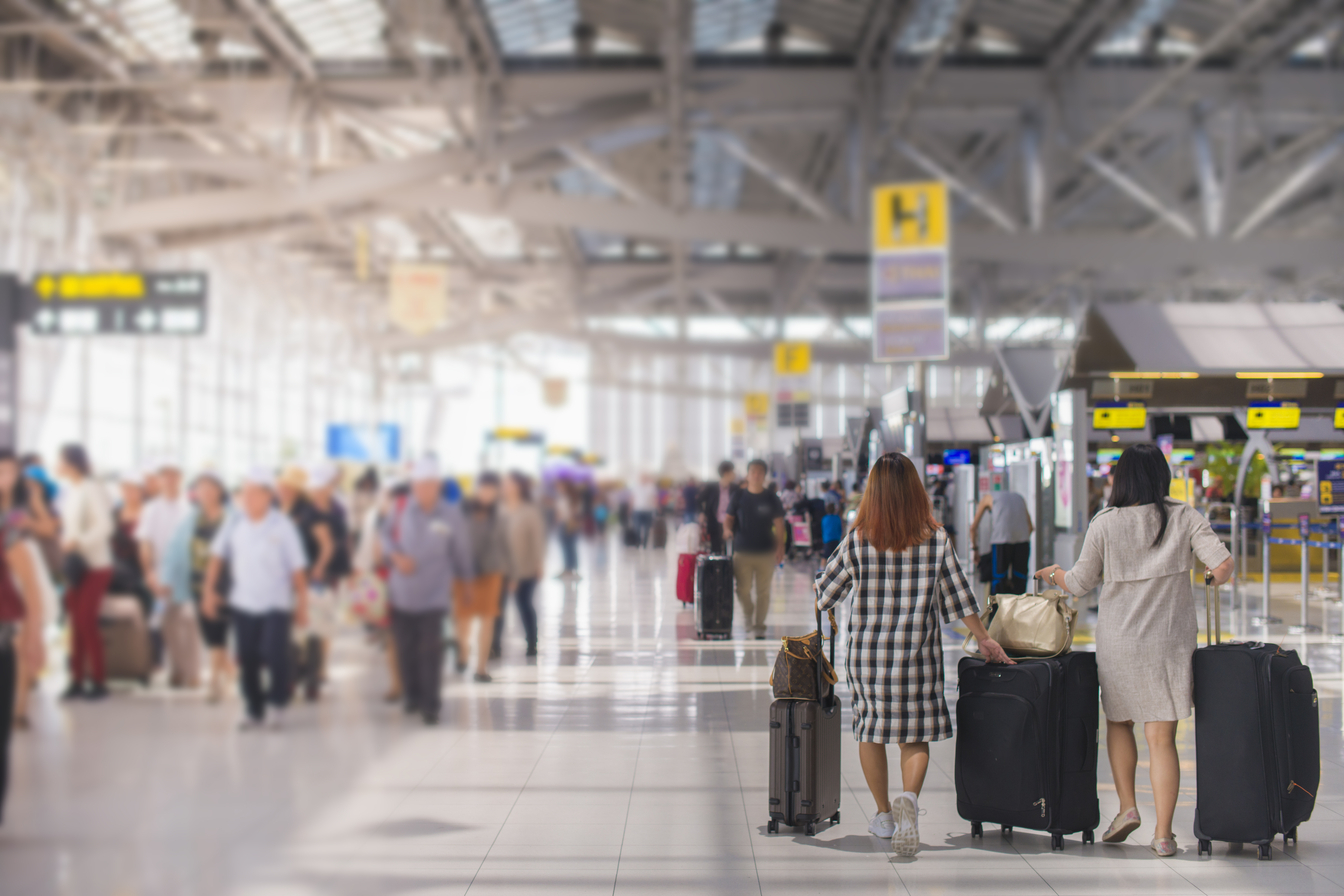 Gente de pie en la terminal de un aeropuerto | Fuente: Shutterstock