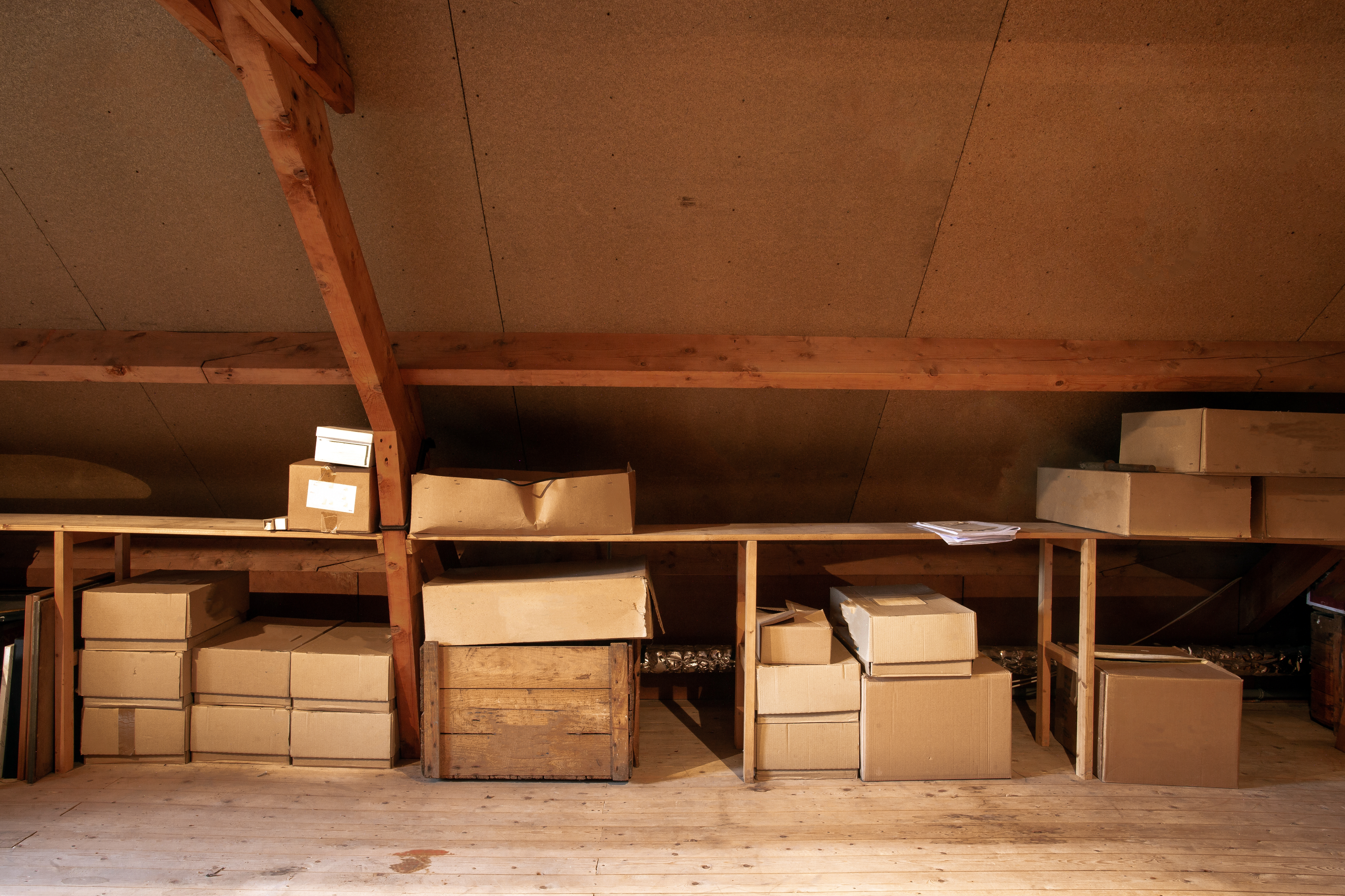 El interior de un viejo desván de madera con viejas cajas de cartón para almacenar | Fuente: Shutterstock