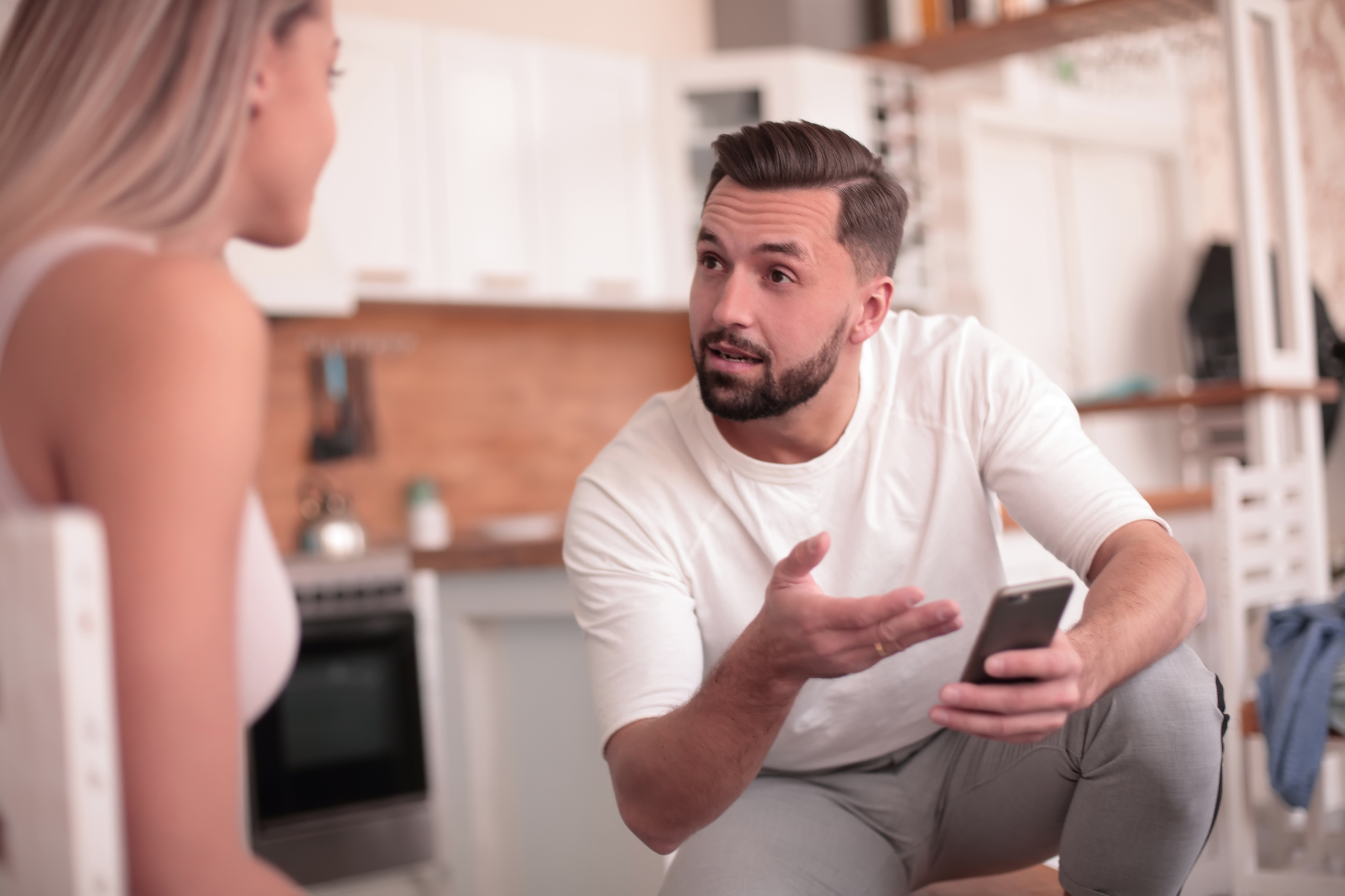 Un joven explicando algo a su esposa | Fuente: Shutterstock