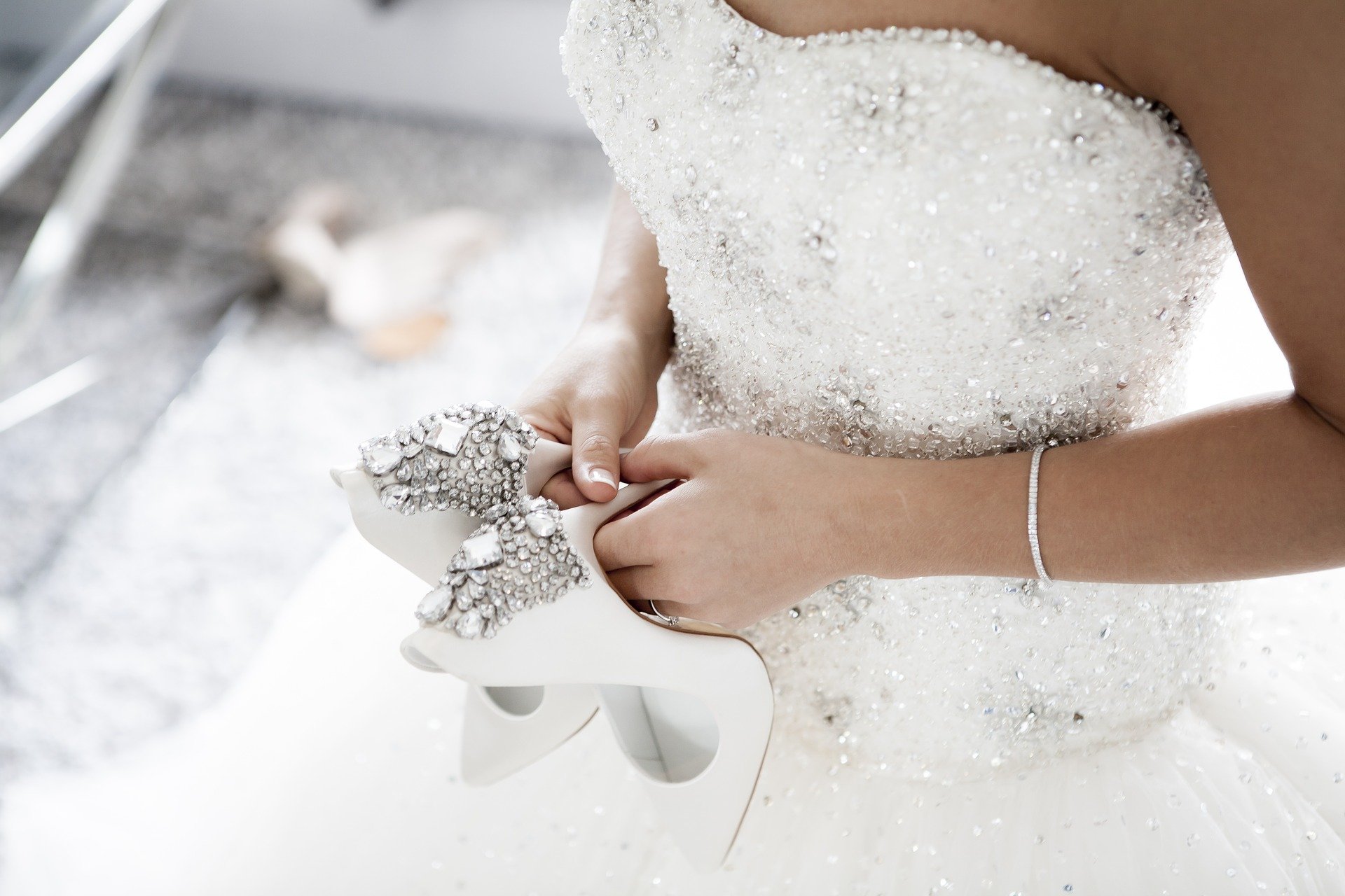 Mujer vestida de novia con zapatos en mano. Fuente: Pixabay
