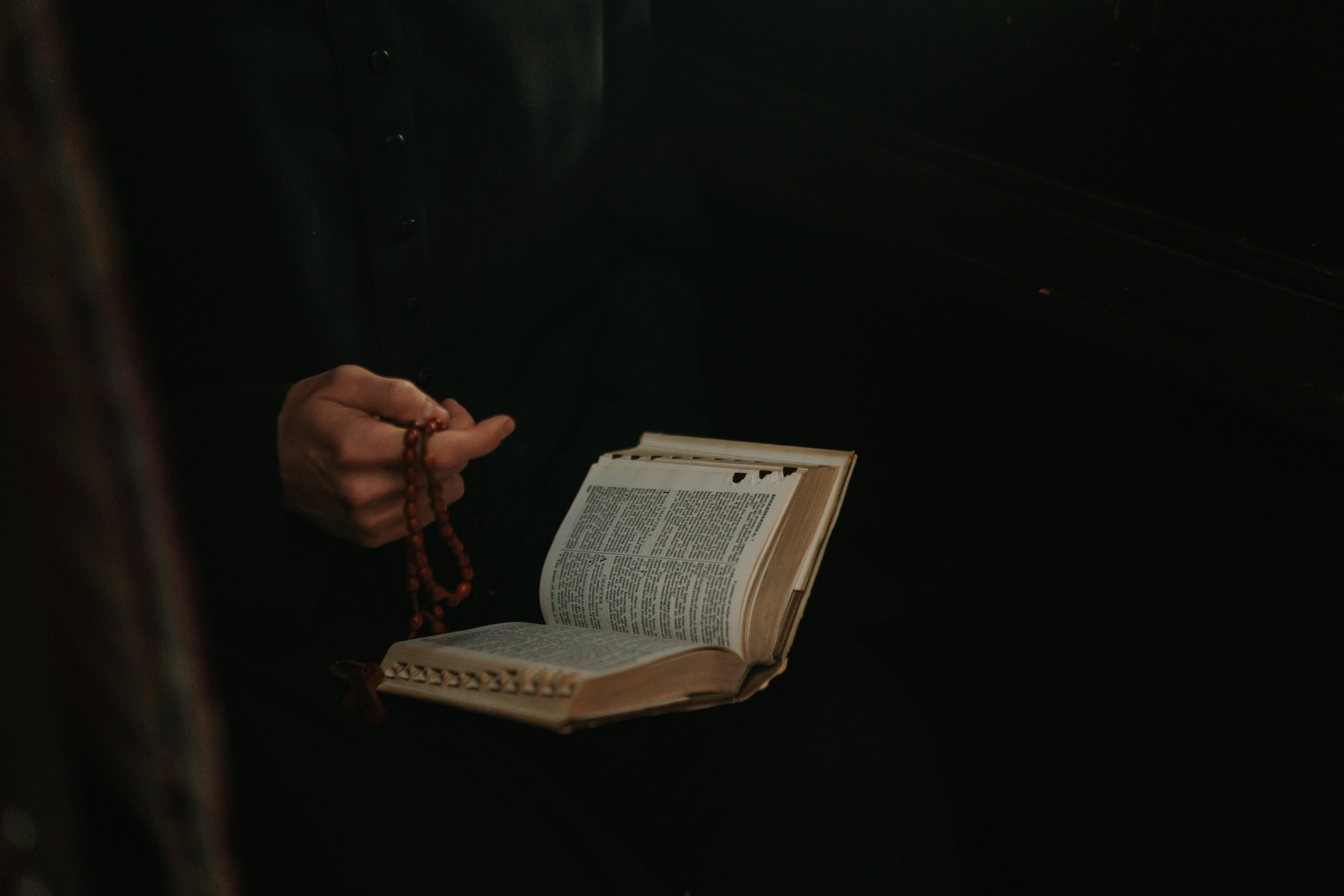 Un pastor sosteniendo un rosario y una biblia | Fuente: Pexels