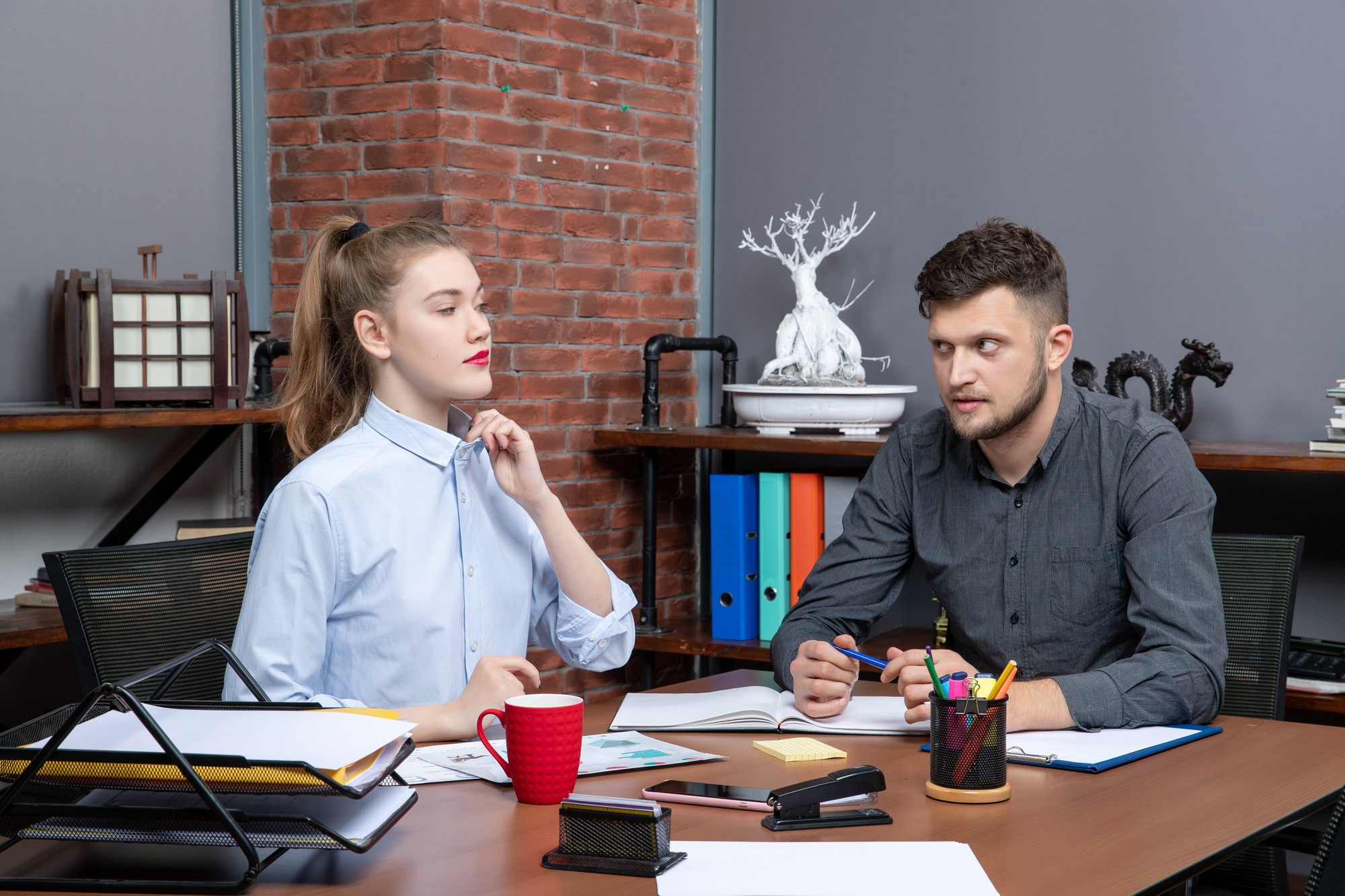 Una mujer estresada hablando con un colega preocupado | Source: Freepik