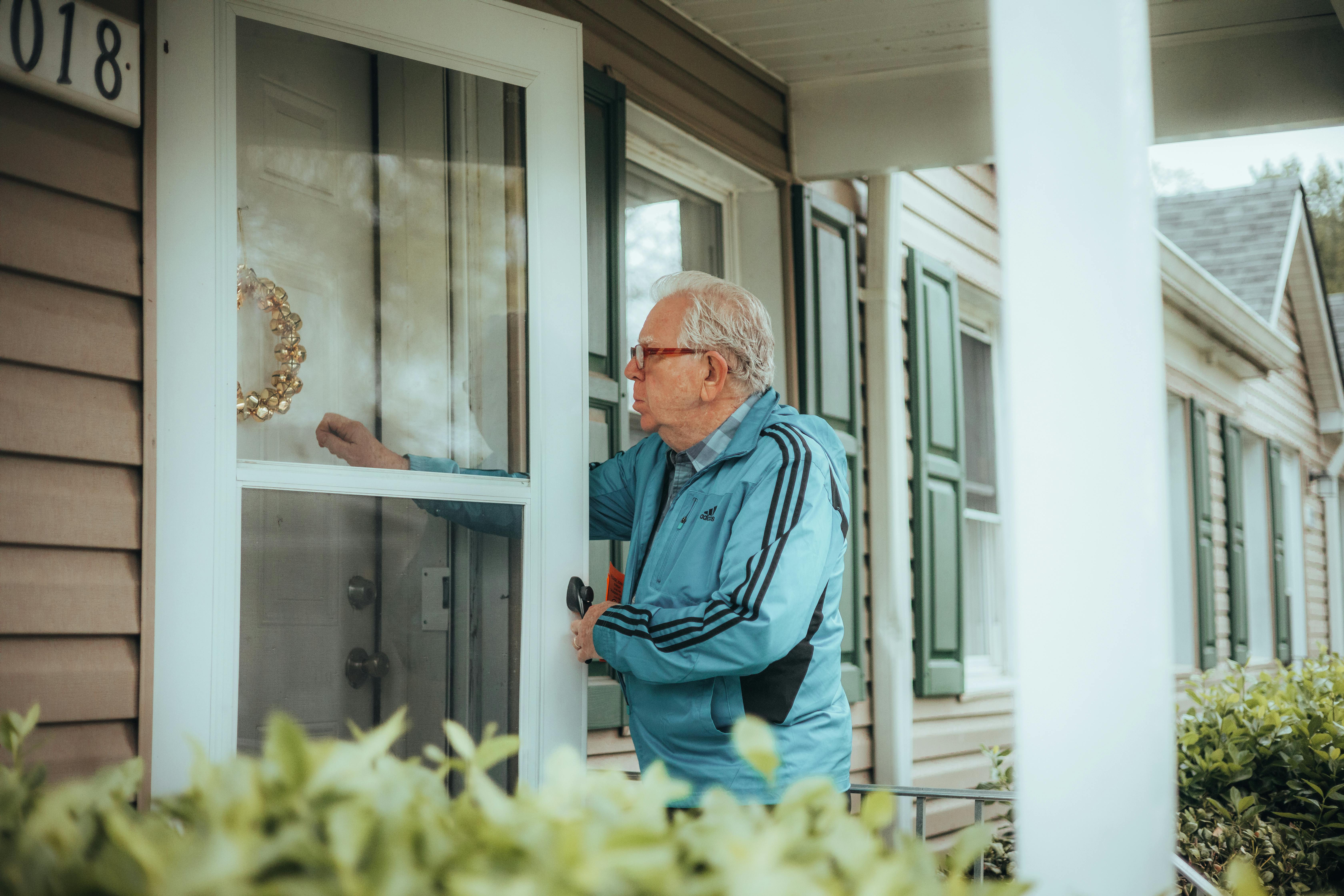 Hombre mayor llamando a la puerta de una casa | Fuente: Pexels