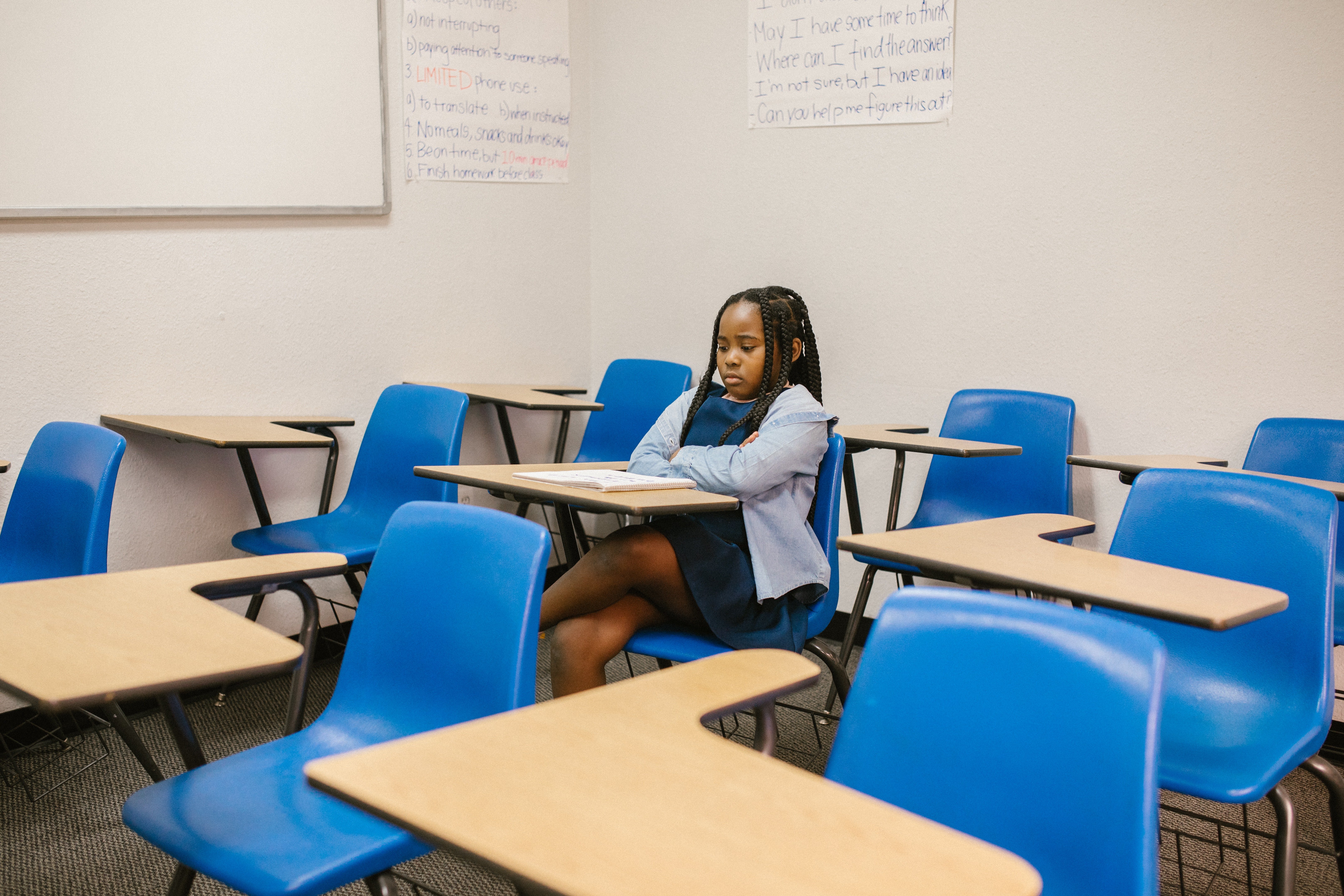 Niña sentada sola en un aula escolar. | Foto: Pexels