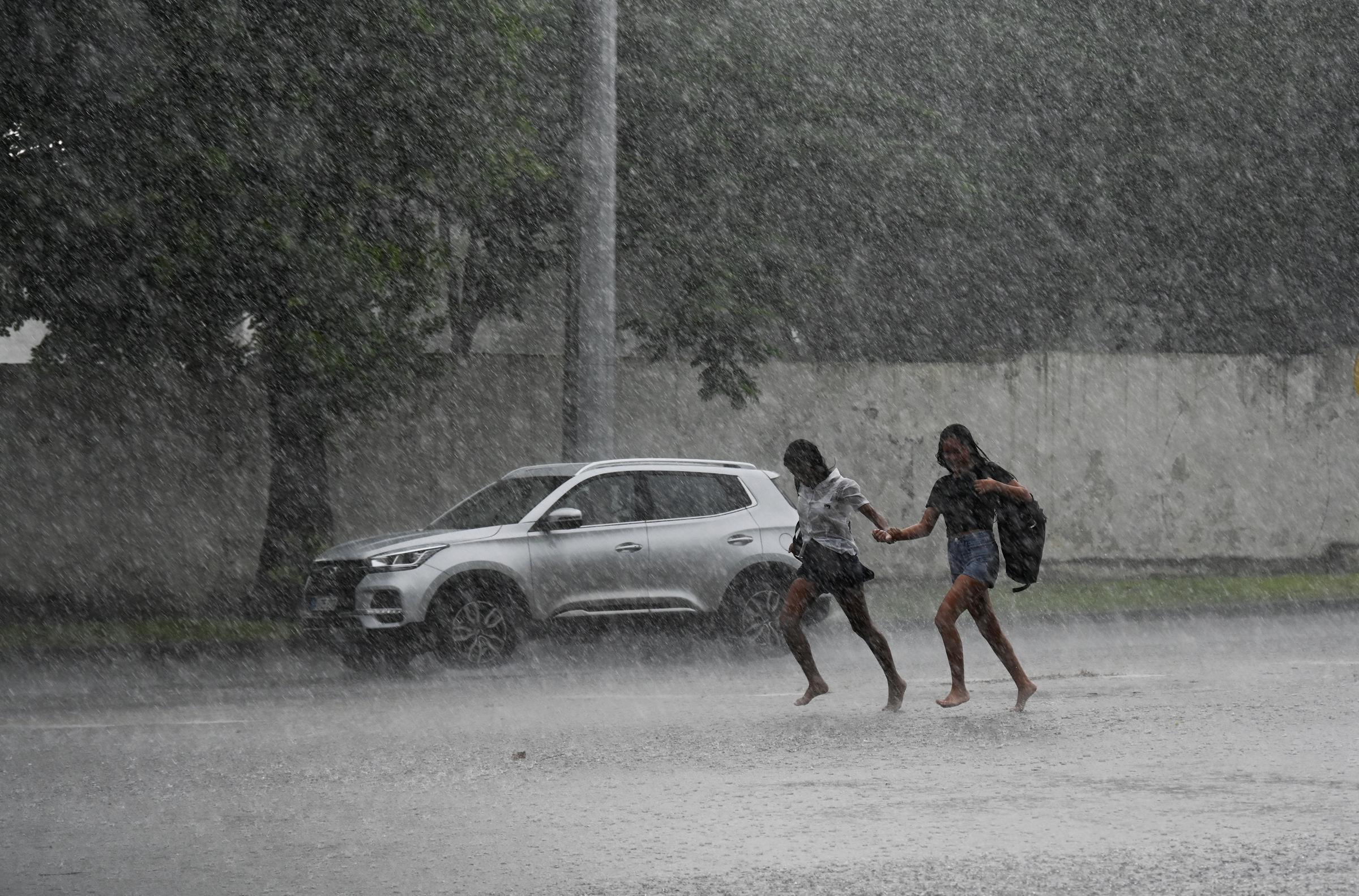 Personas corren bajo una lluvia torrencial en La Habana debido al paso del huracán Milton el 9 de octubre de 2024 | Fuente: Getty Images