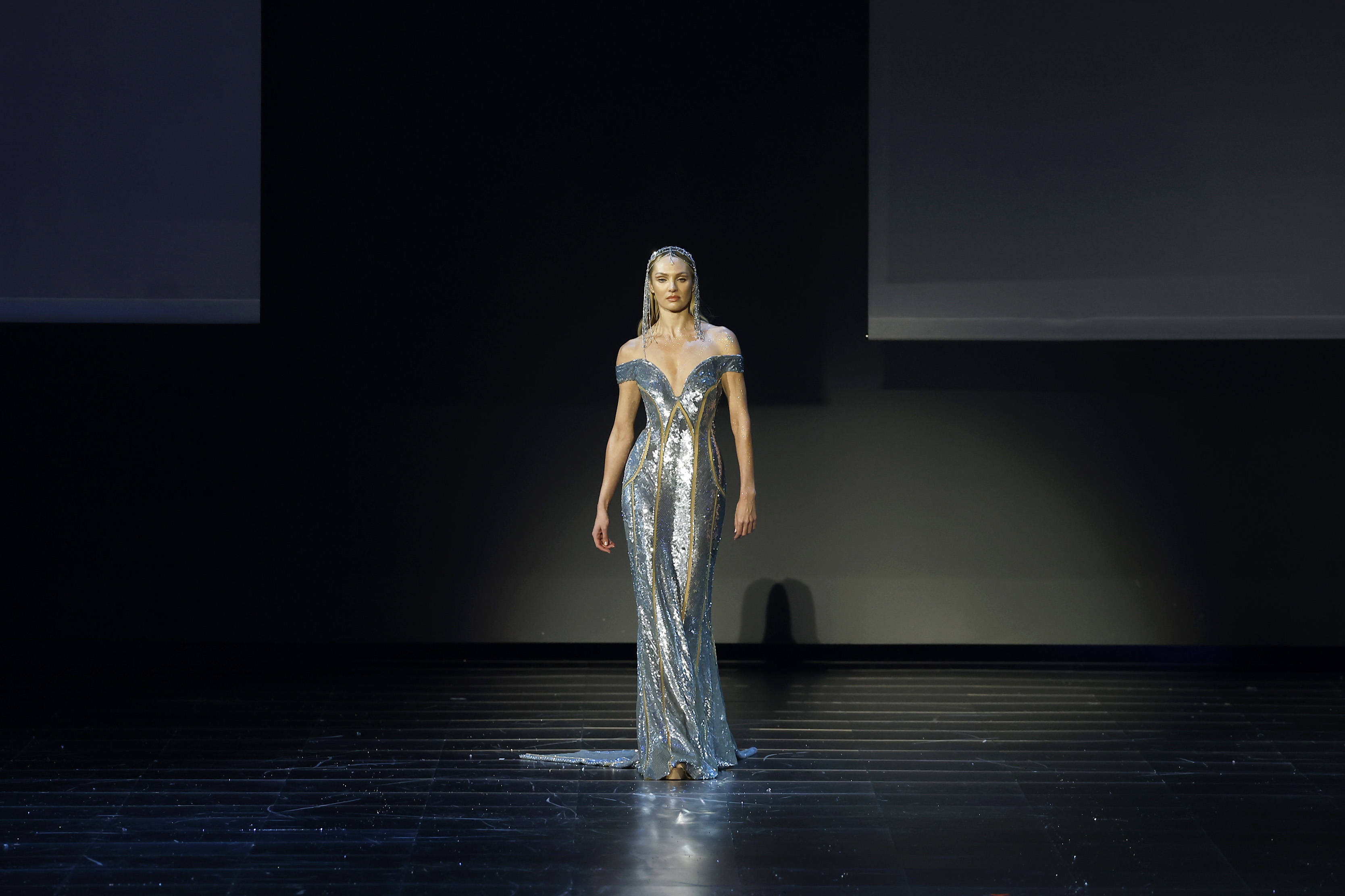Candice Swanepoel lleva el mismo vestido que Klum mientras desfila en la pasarela del desfile "1001 Seasons" de Elie Saab el 13 de noviembre de 2024, en Arabia Saudita. Está impresionante con el diseño, aunque la aparición de Klum en la alfombra roja da al vestido una presencia más completa.
