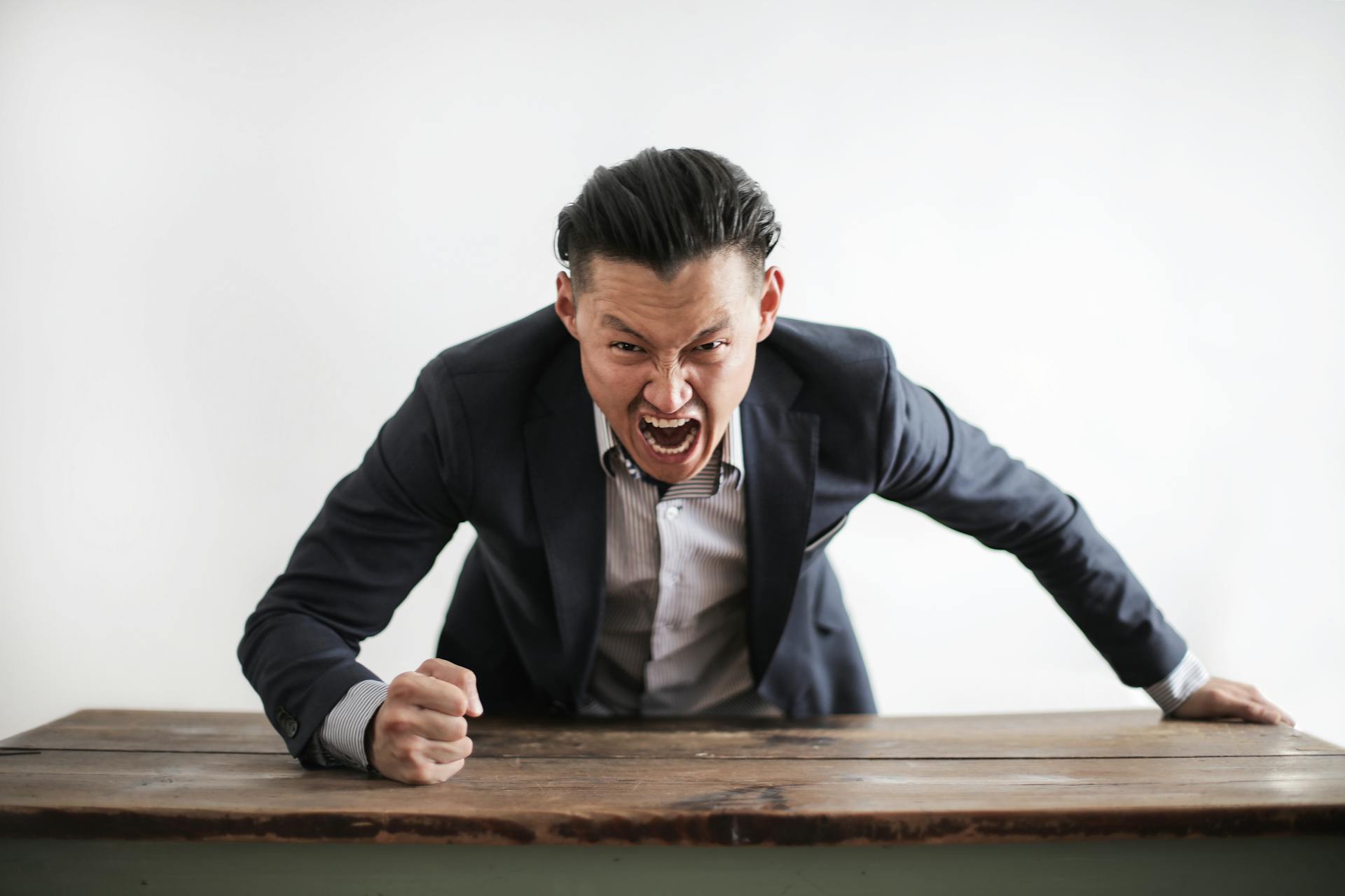 Un hombre furioso golpea un escritorio | Fuente: Pexels