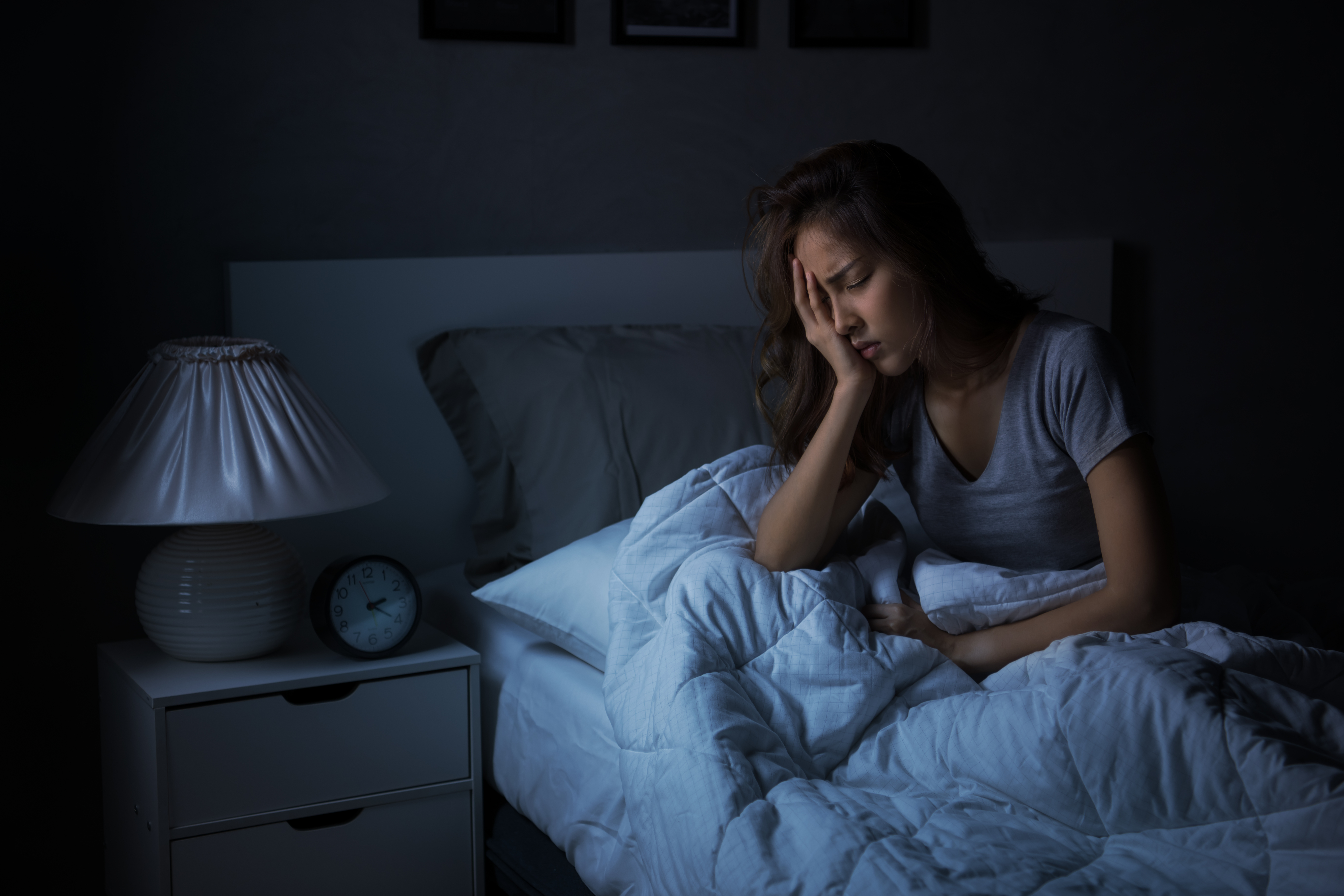Joven deprimida sentada en la cama sin poder dormir por insomnio. | Fuente: Shutterstock