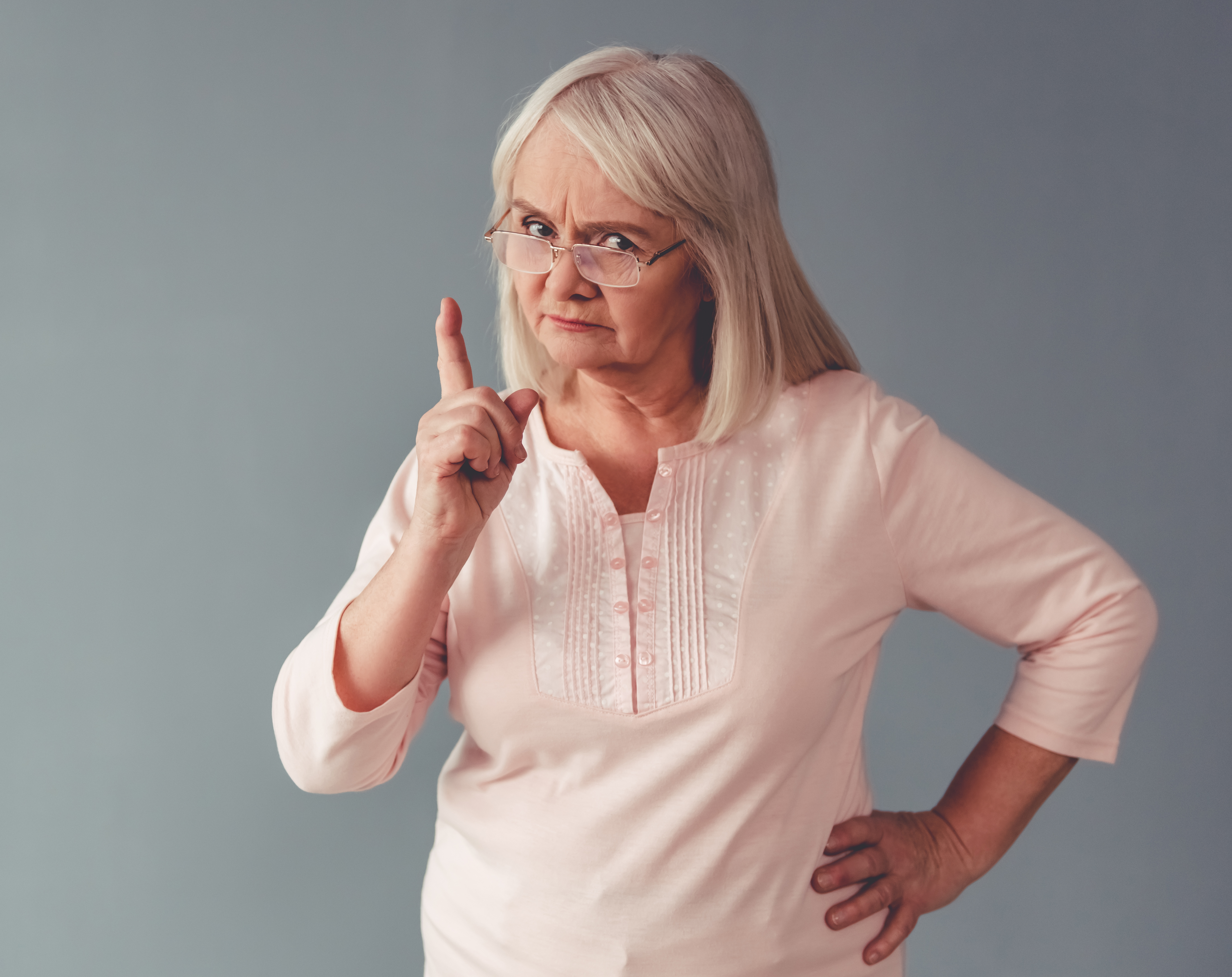 Una mujer mayor enfadada advirtiendo con el dedo | Fuente: Shutterstock