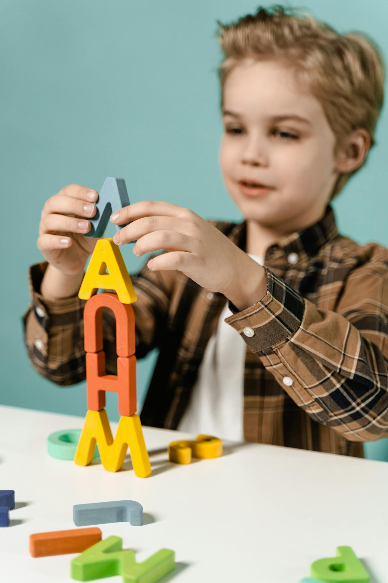 Un niño apilando bloques de letras | Fuente: Pexels