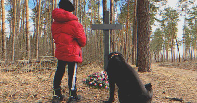 Un niño y un perro frente a una tumba | Foto: Shutterstock