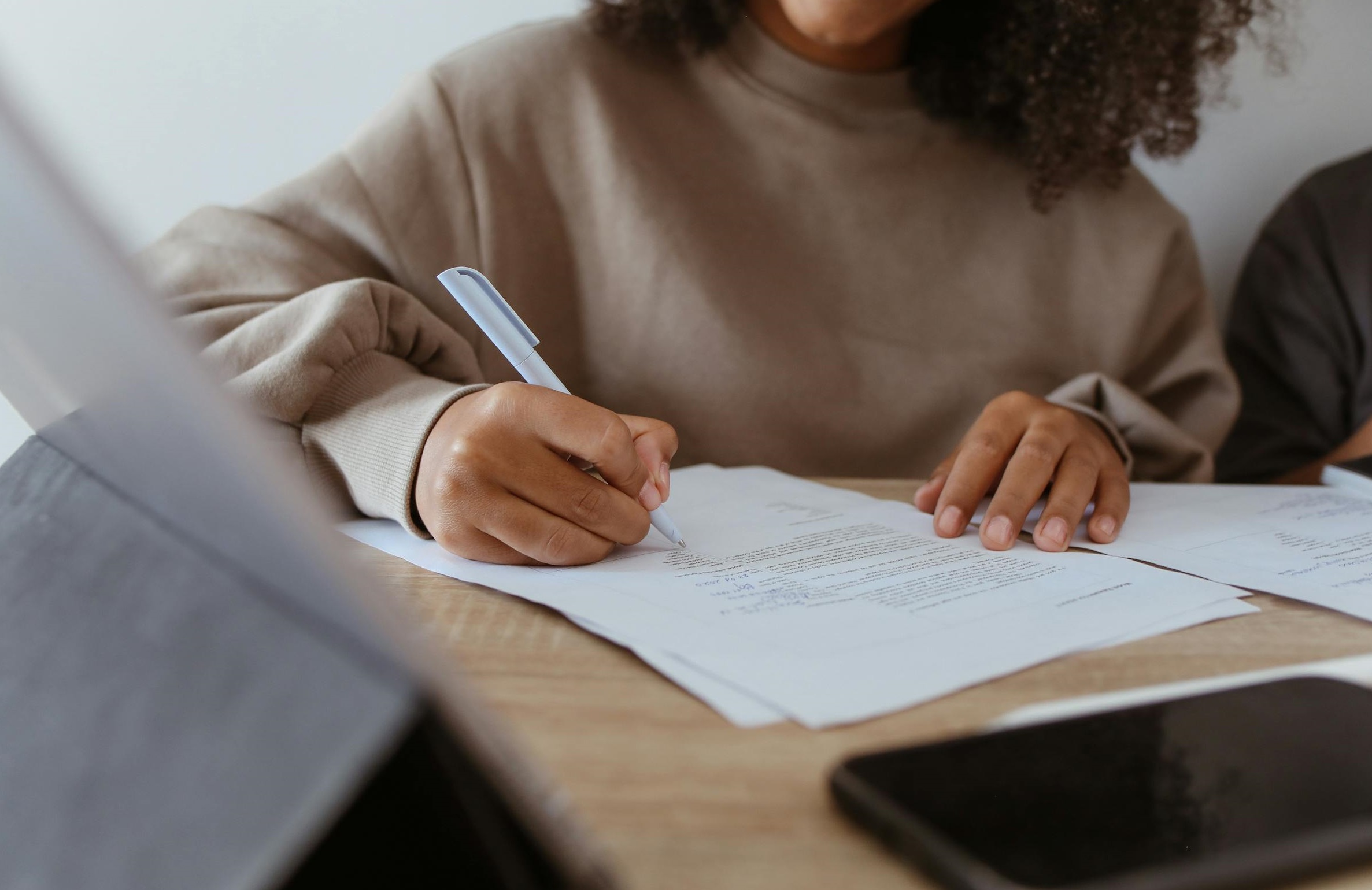 Una mujer firmando papeles | Fuente: Pexels