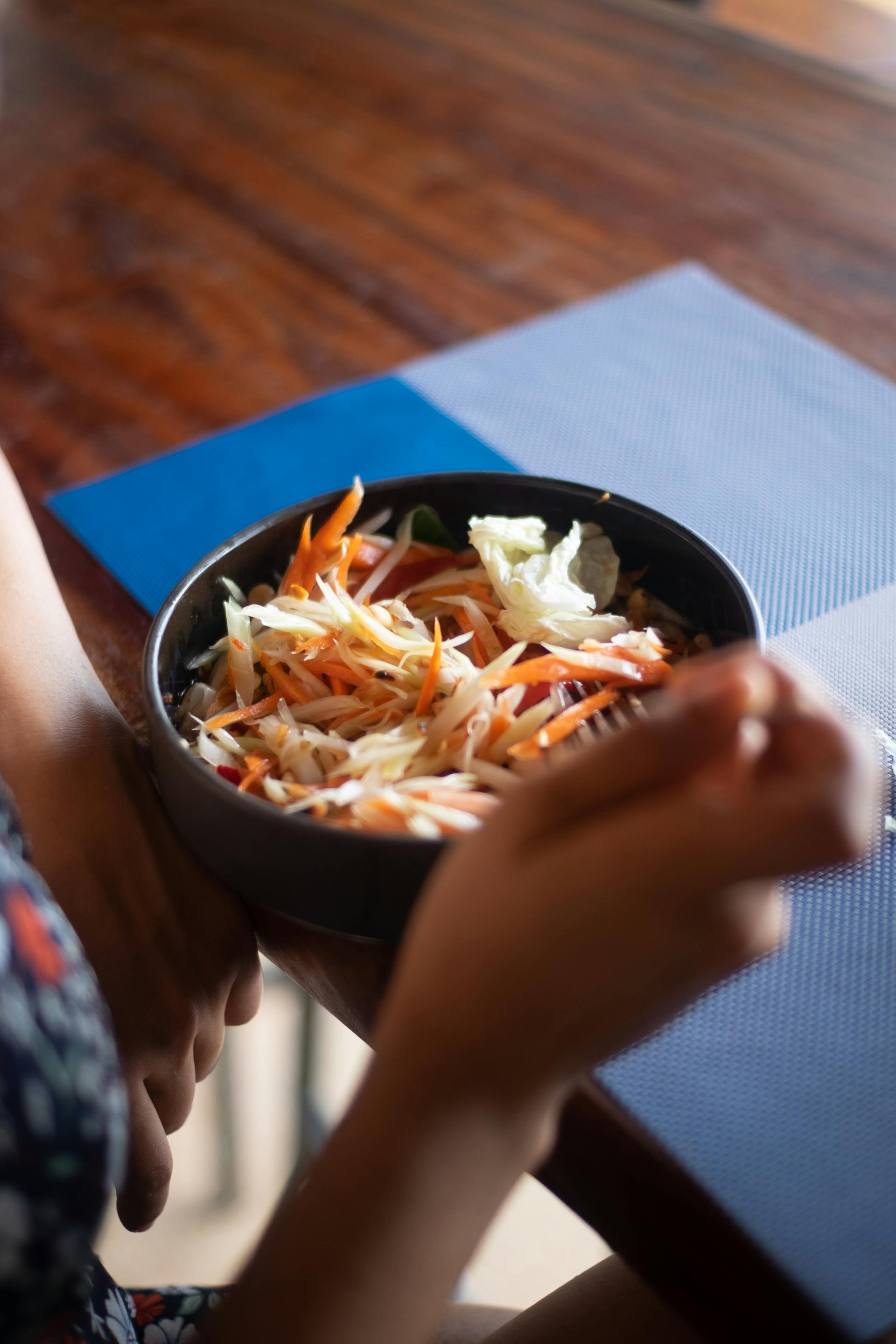 Primer plano de una persona comiendo ensalada en un restaurante | Fuente: Pexels