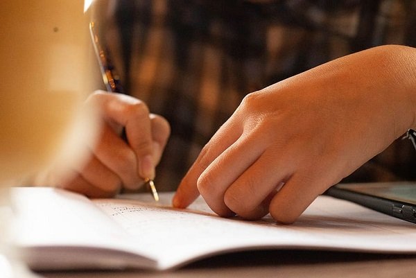Persona joven escribiendo con una pluma. | Foto: Pxfuel