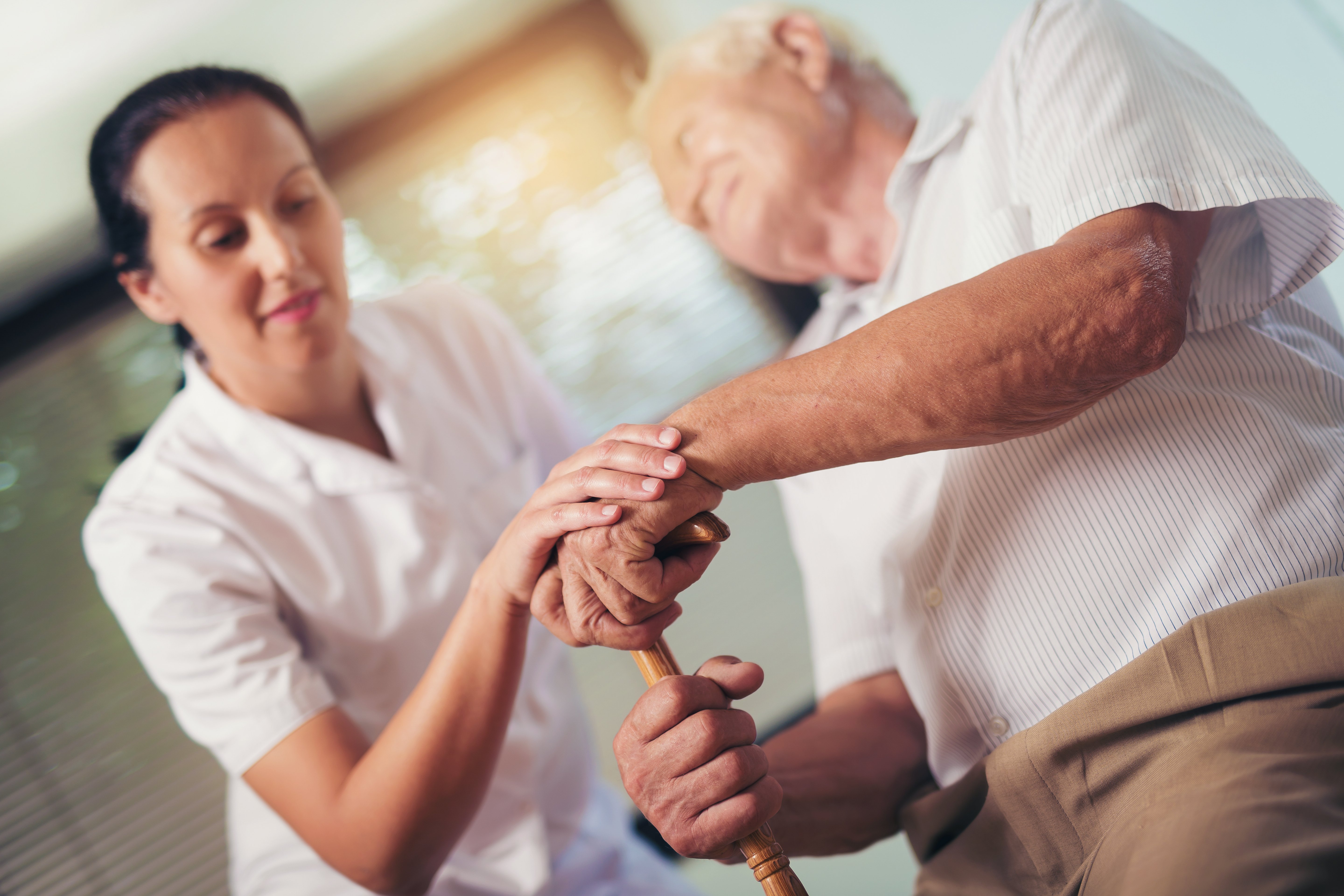Anciano junto a una enfermera. Fuente: Shutterstock