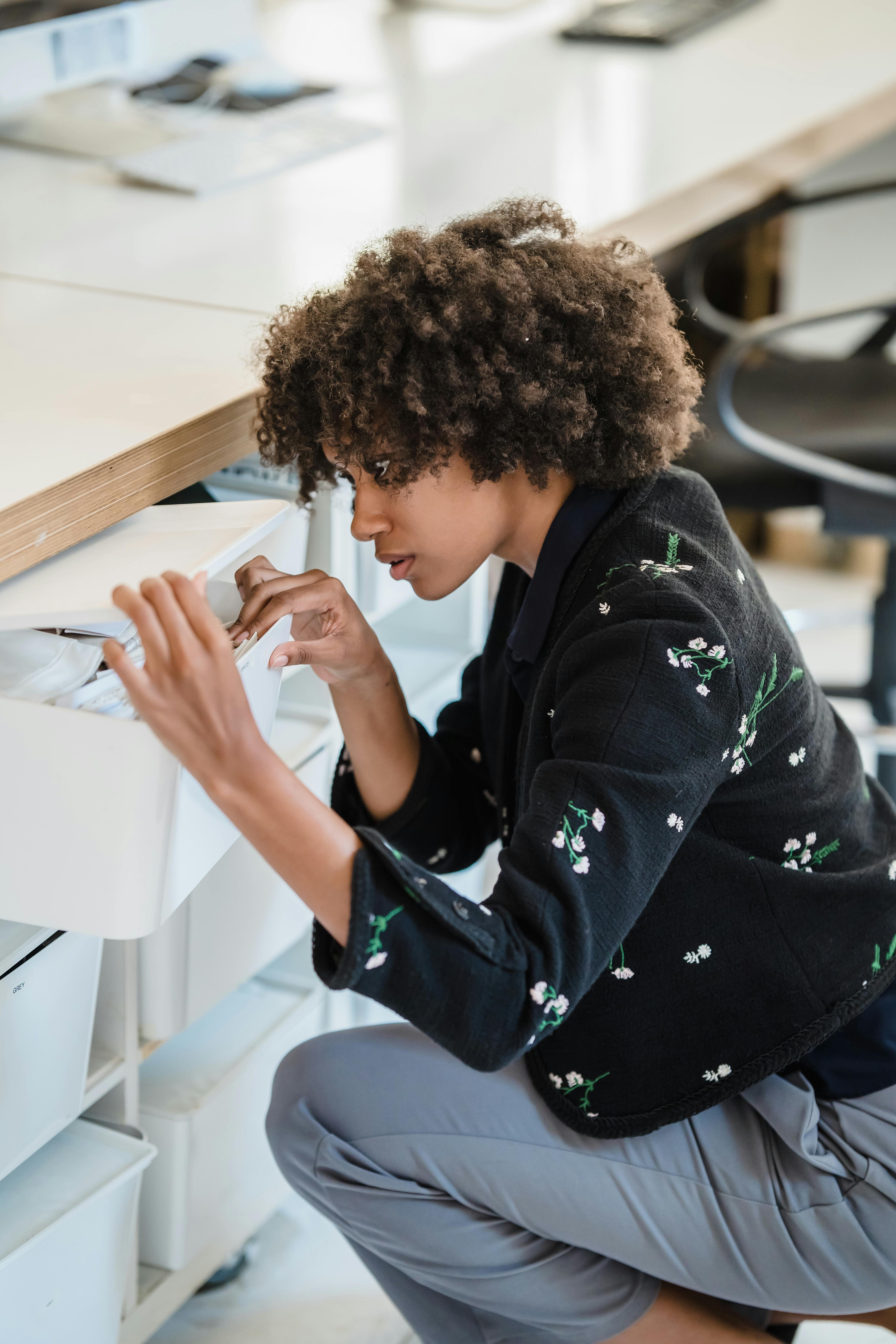 Una mujer buscando en los cajones de un escritorio | Fuente: Pexels