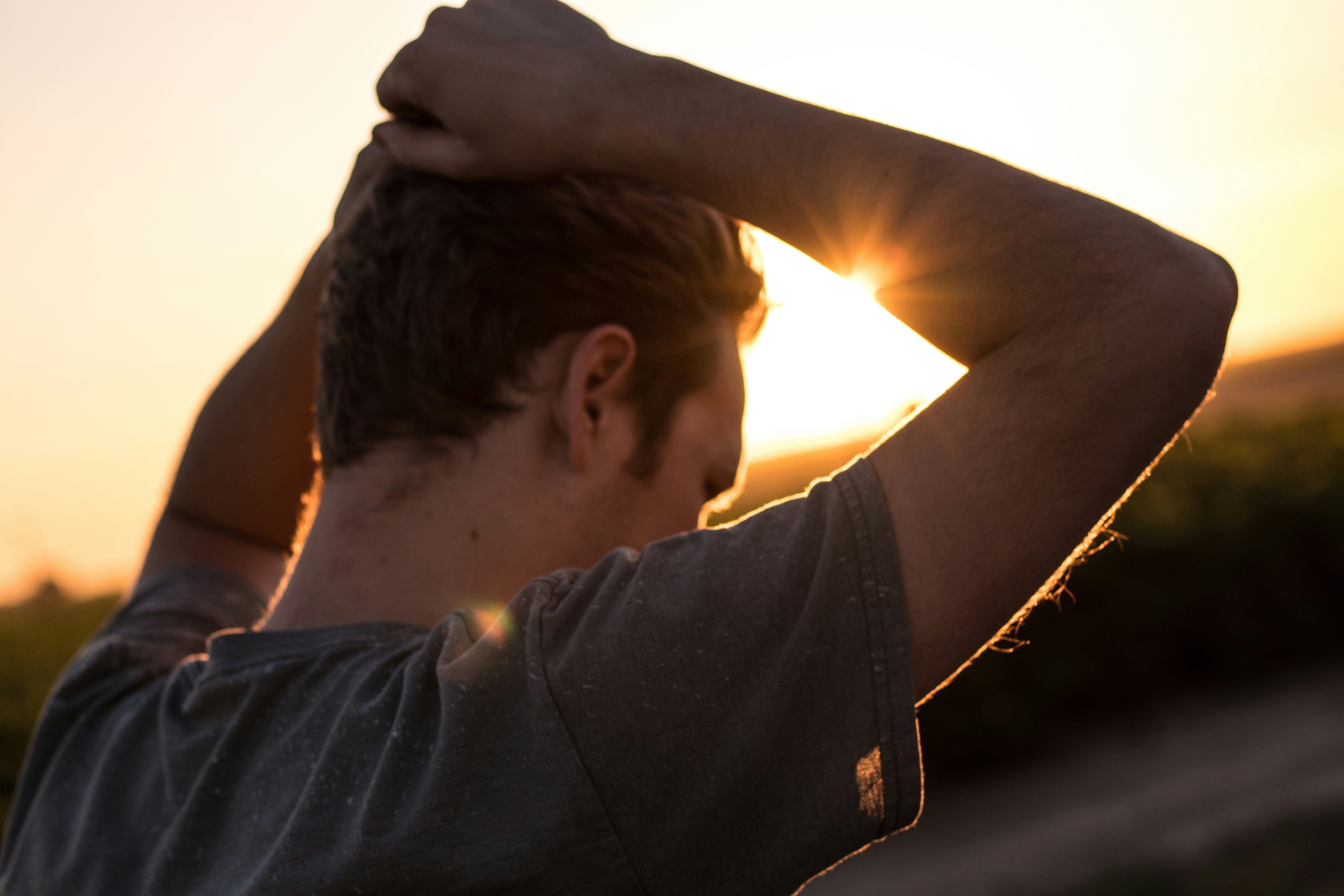 Un hombre de pie al aire libre con las manos en la cabeza | Fuente: Unsplash