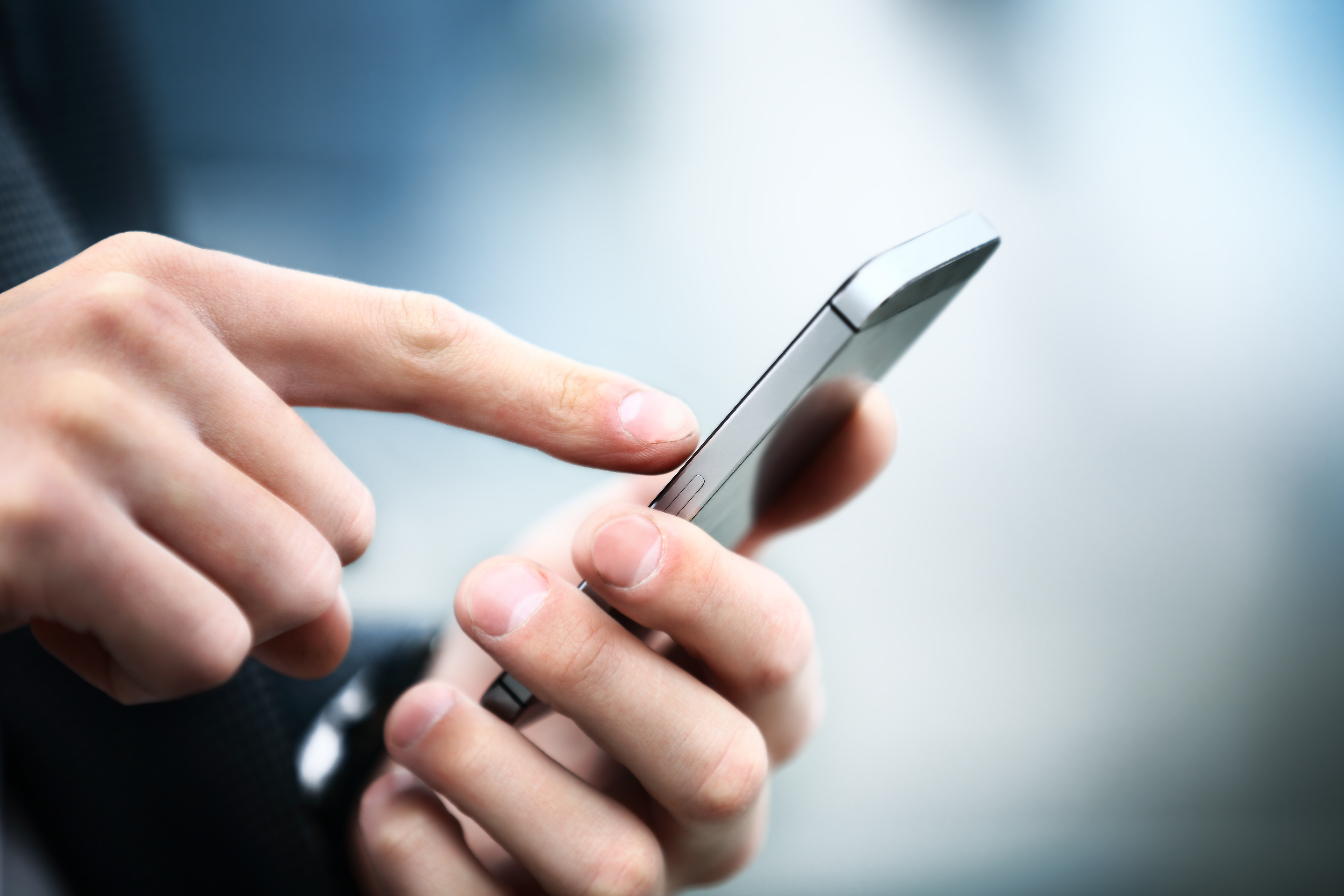 Primer plano de un hombre utilizando un teléfono móvil inteligente | Fuente: Shutterstock