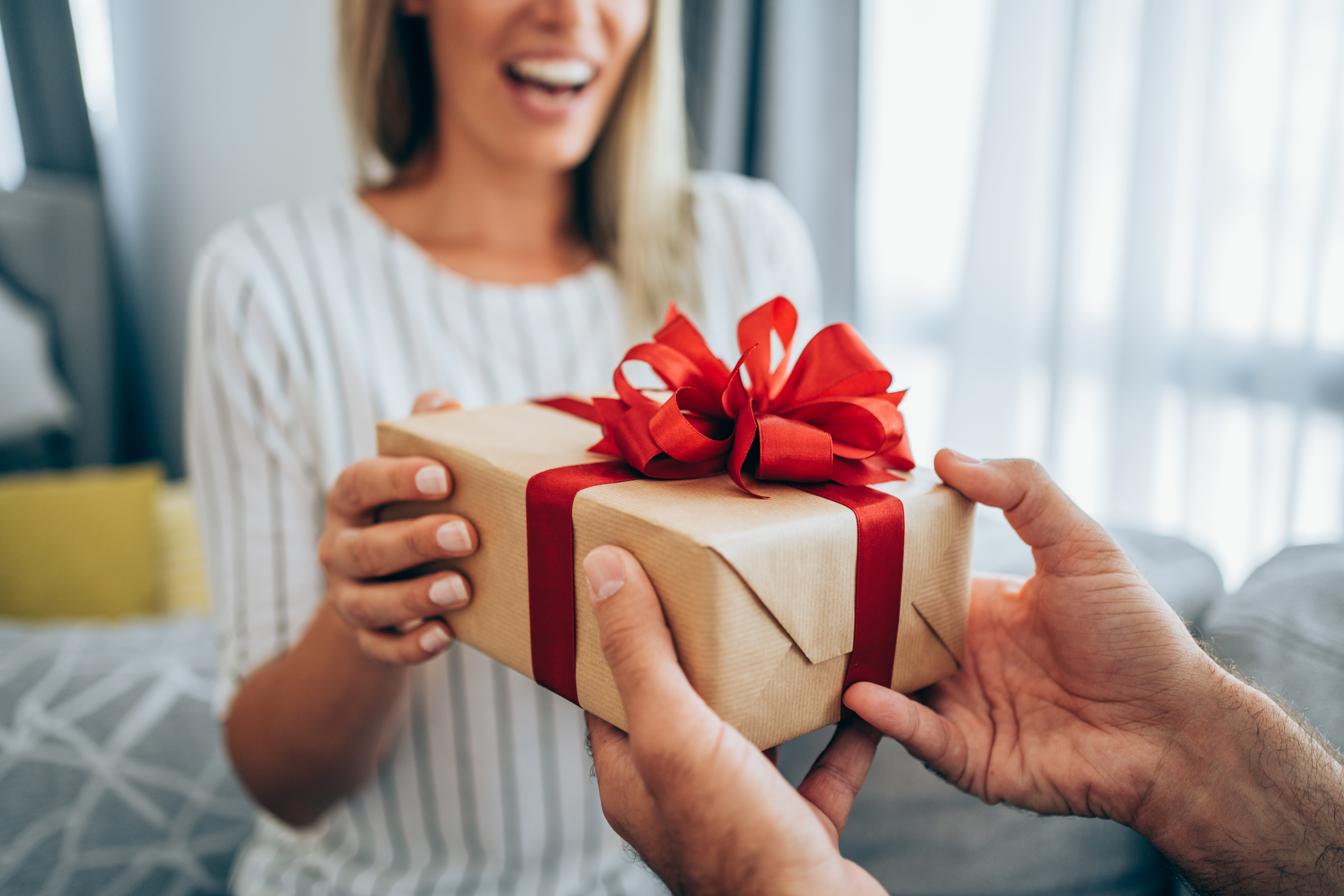 Mujer feliz recibiendo un regalo de un hombre | Fuente: Getty Images