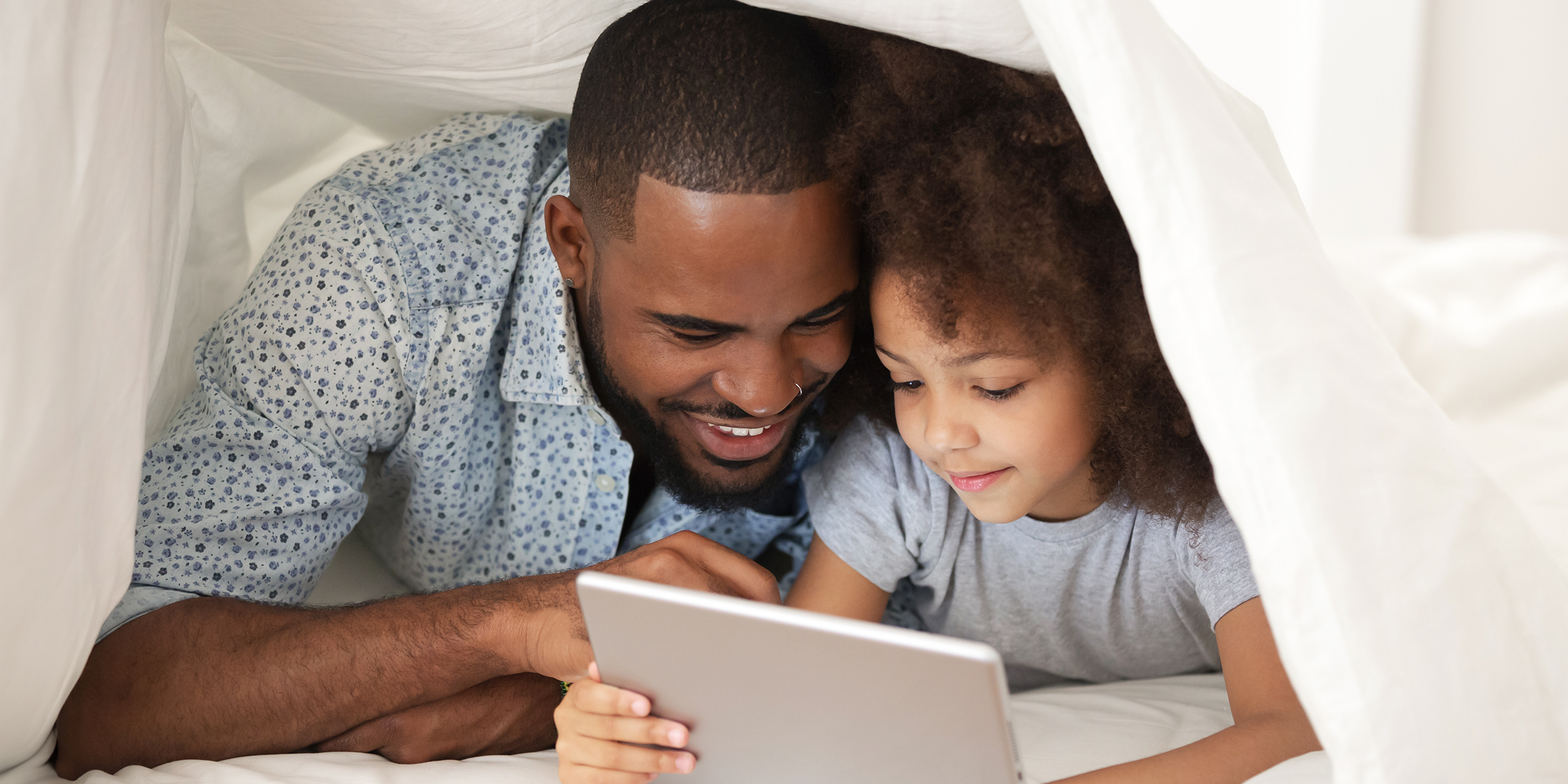 Padre e hija utilizando una Tablet | Fuente: Shutterstock