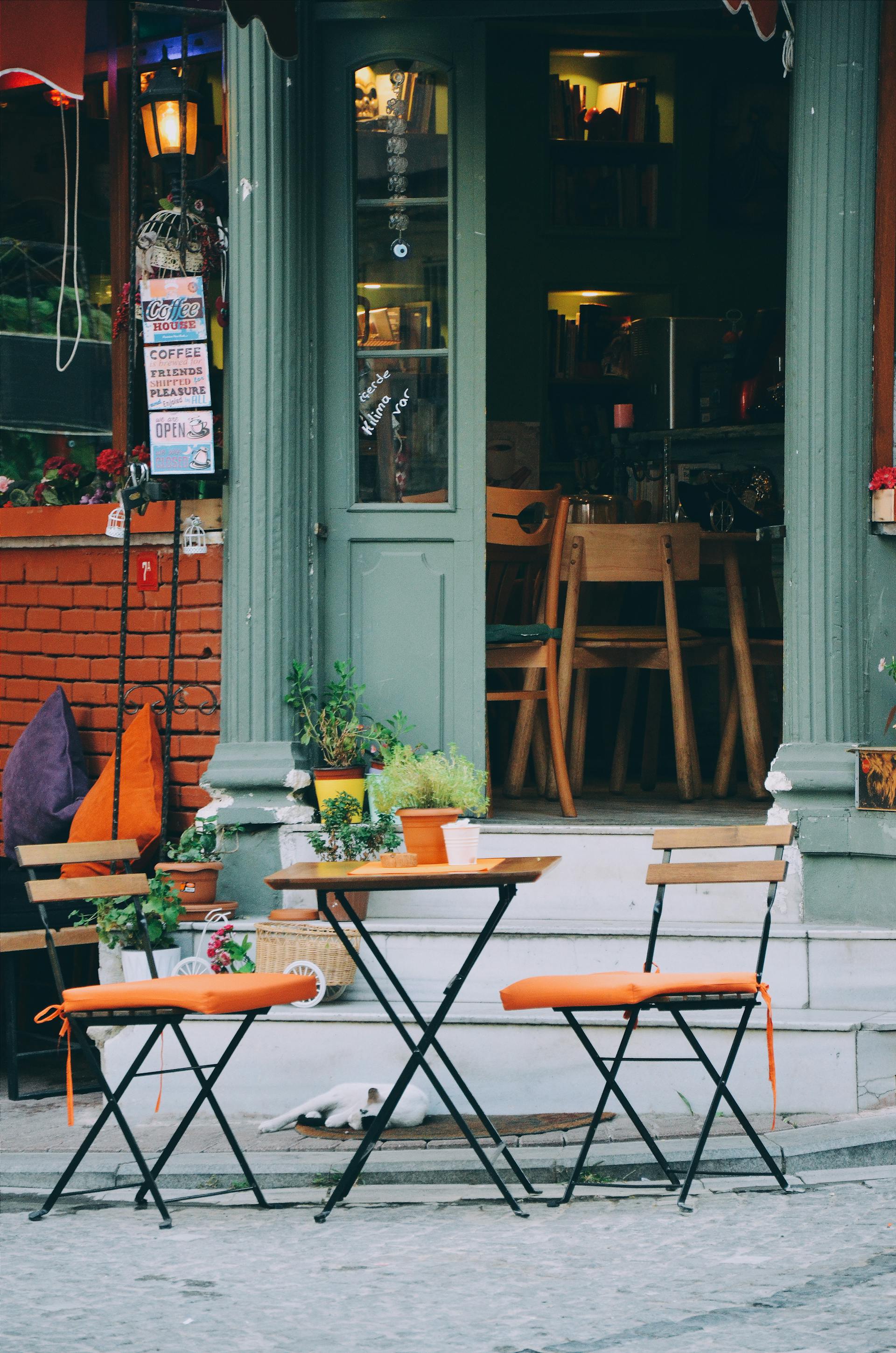 Un juego de patio de tres piezas marrón y naranja en el exterior de una cafetería | Foto: Pexels