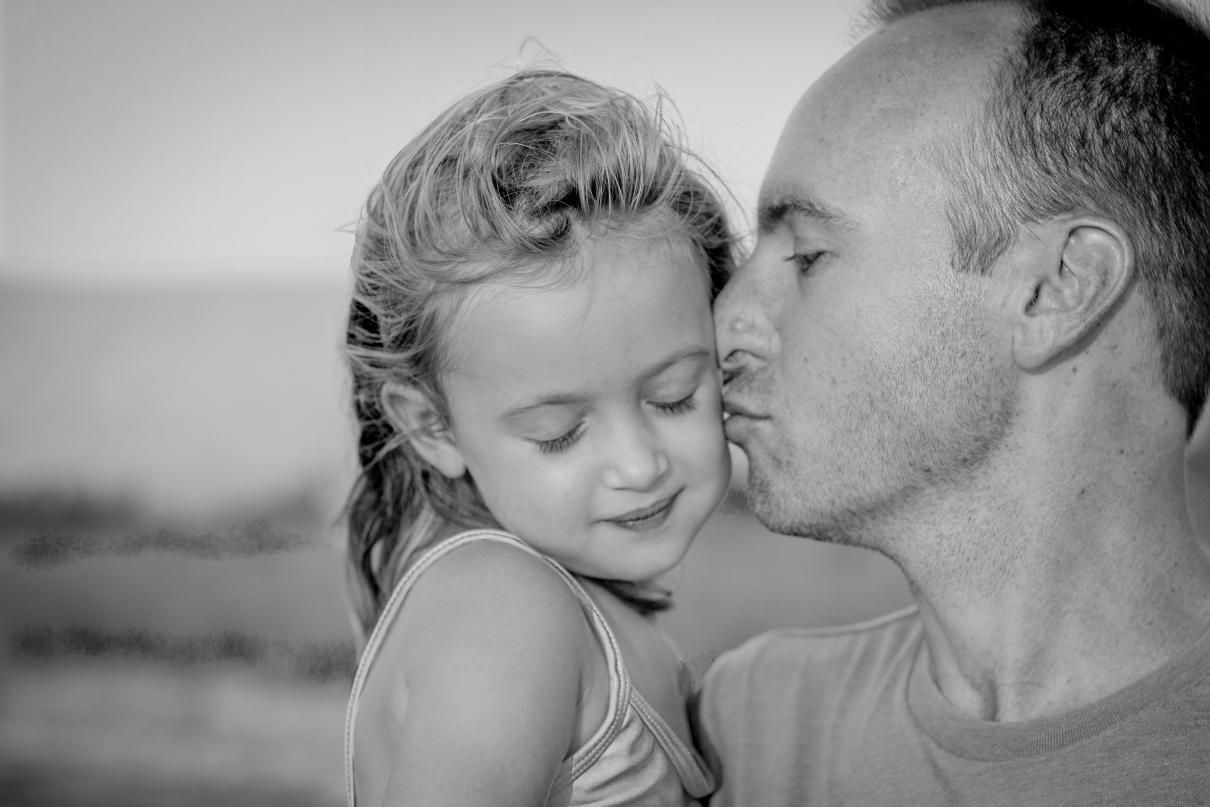 Padre besando a su hija en la mejilla | Foto: Unsplash
