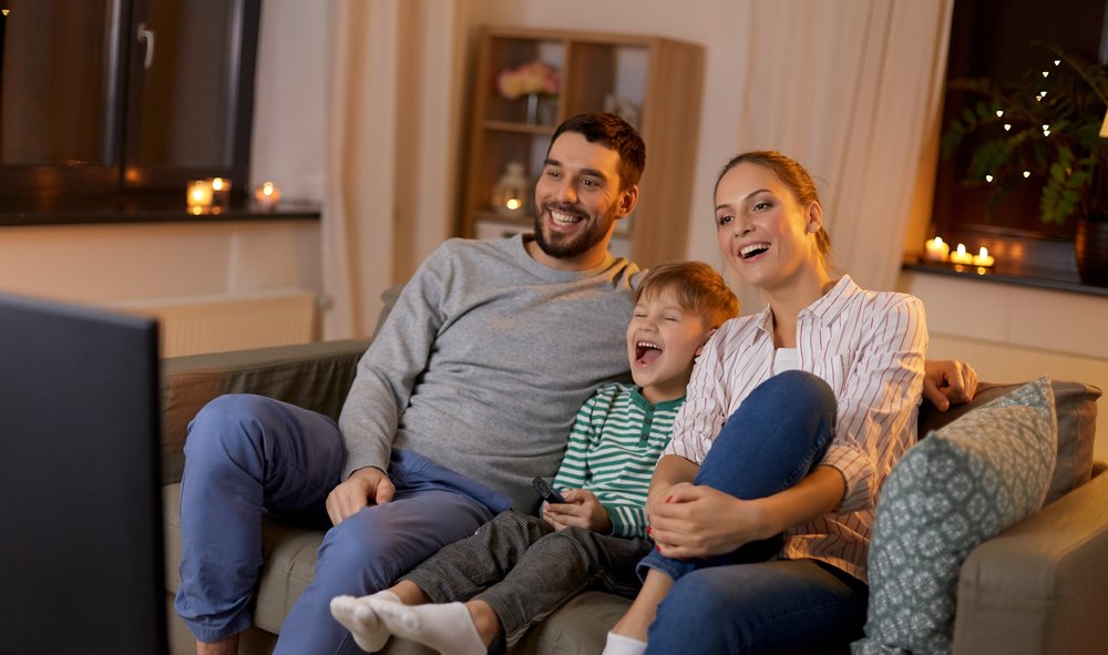 Familia viendo televisión en el sofá. | Foto: Shutterstock