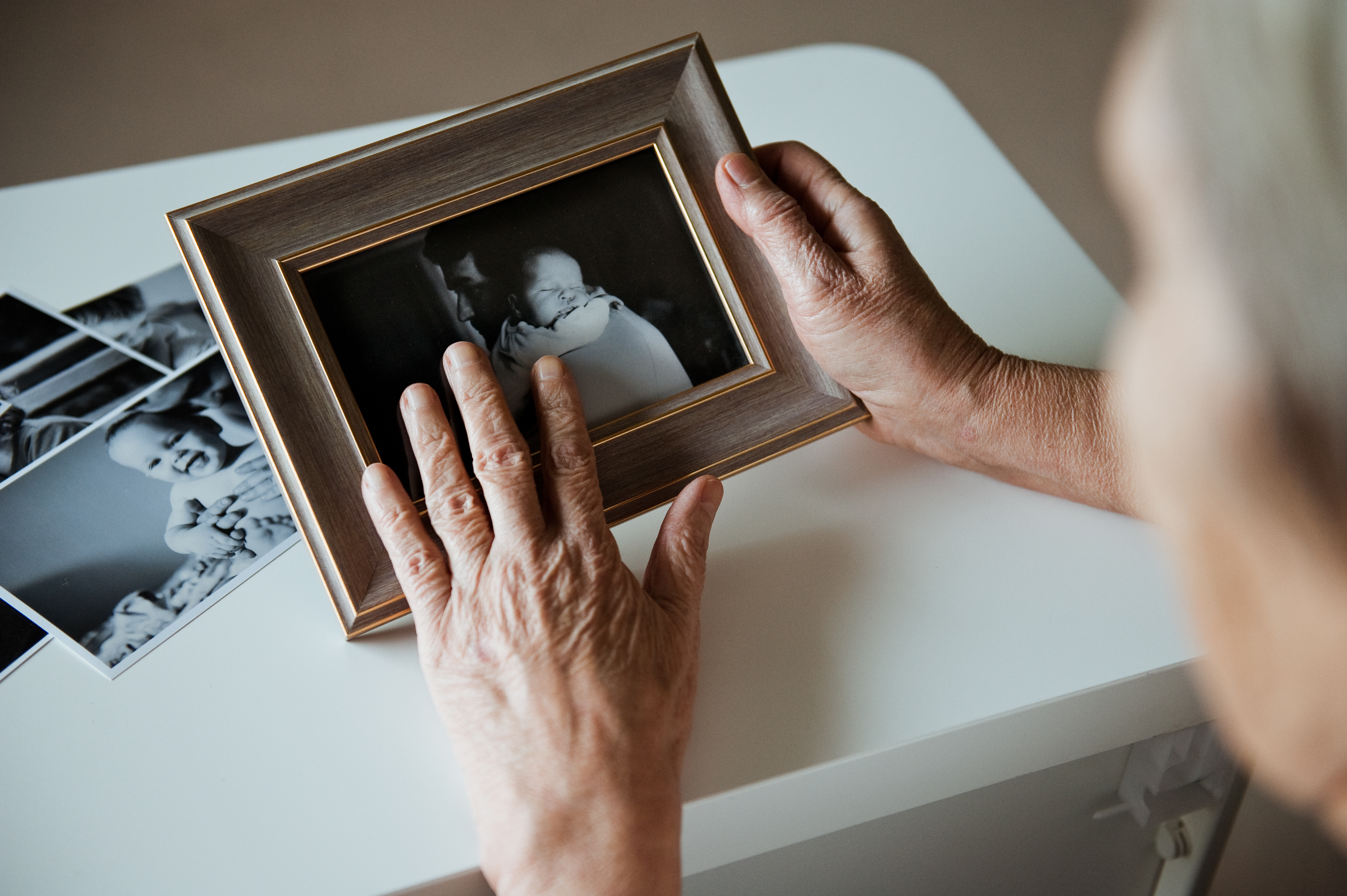 Una anciana sujetando un marco de fotos | Foto: Shutterstock