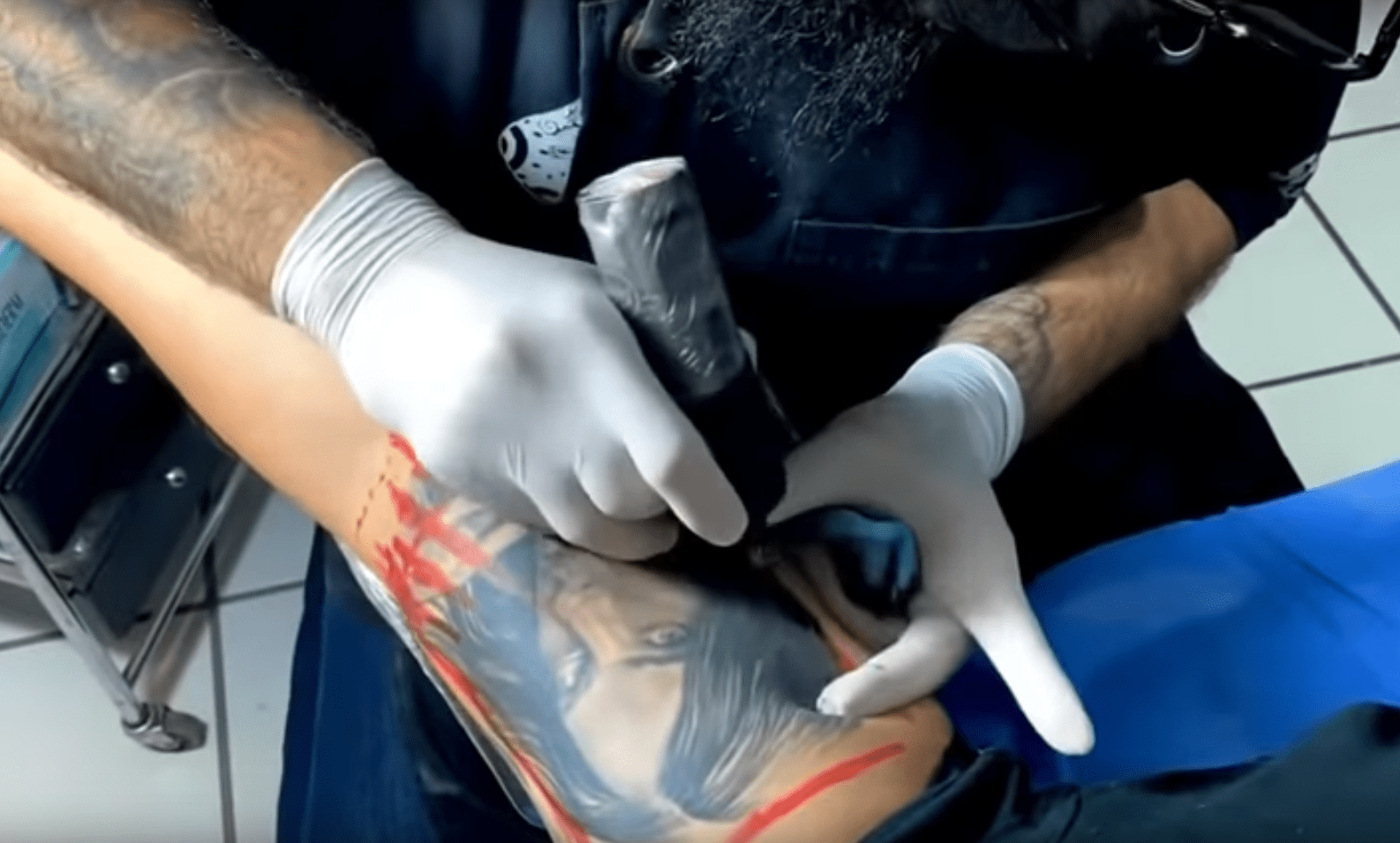 Lupillo Rivera en el proceso de cobertura del tatuaje del rostro de Belinda. | Foto: YouTube/Lupillo Rivera