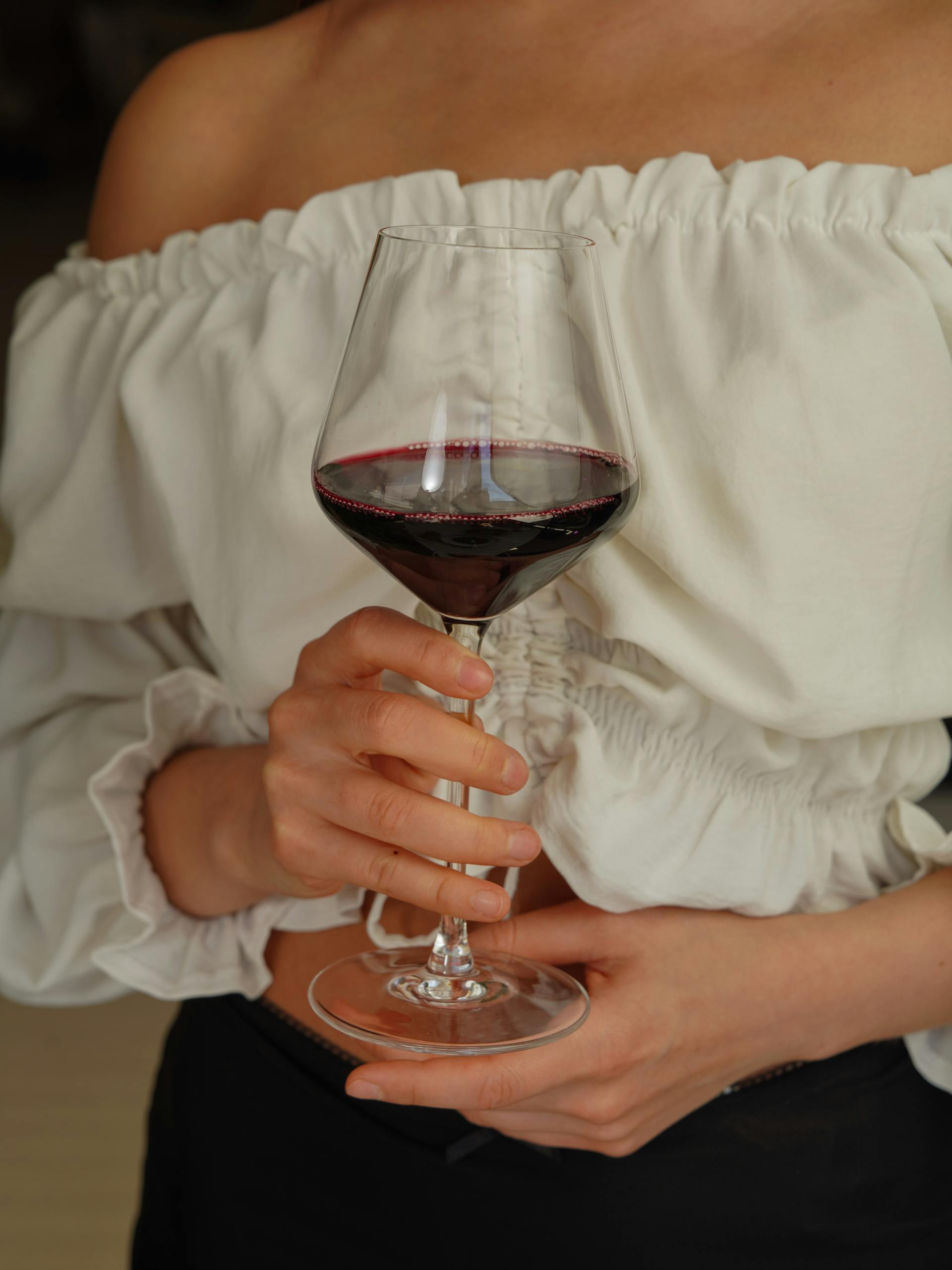 Una mujer con una copa de vino en la mano | Fuente: Pexels