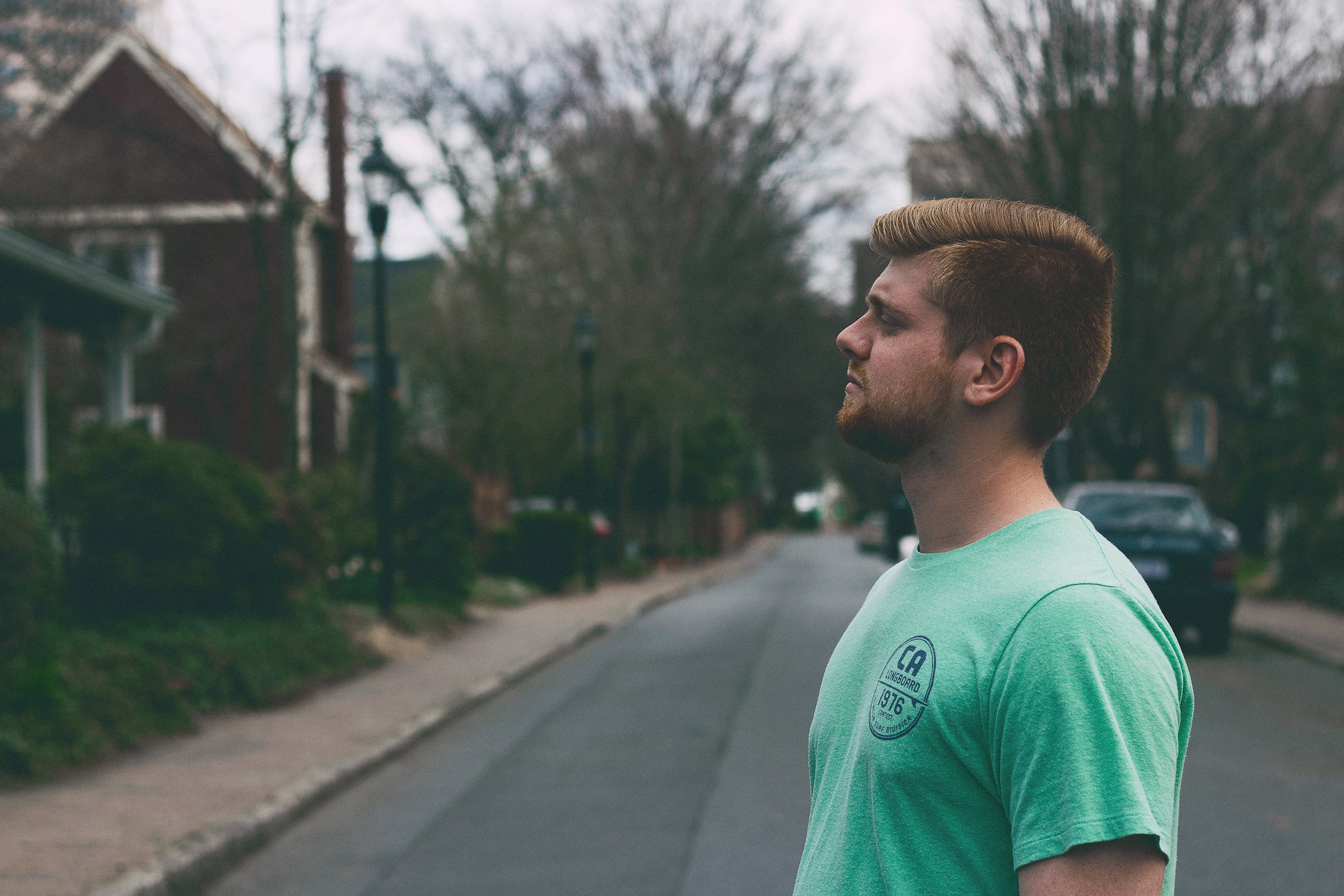 Un hombre con una camiseta verde en el exterior de una casa durante el día | Fuente: Unsplash