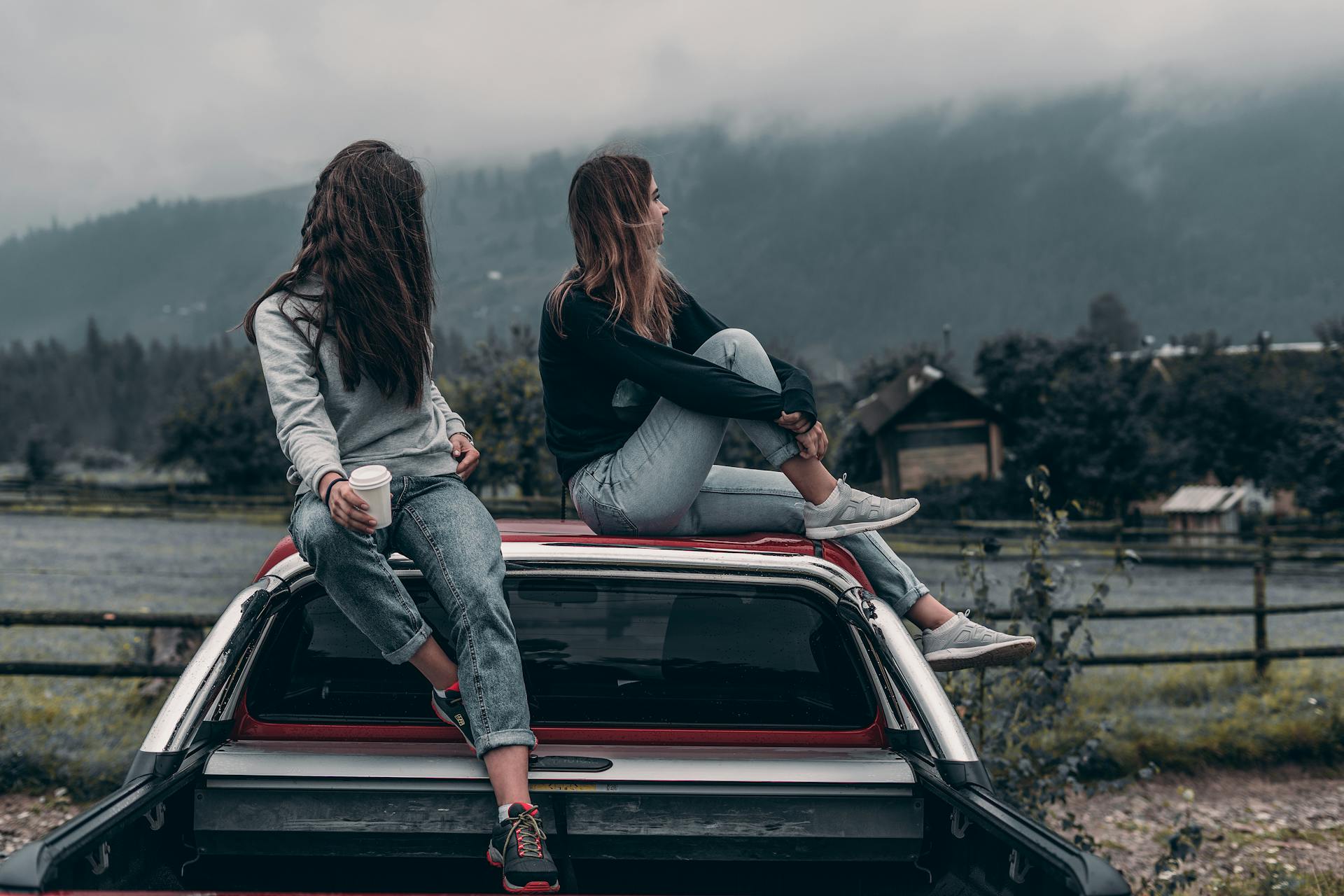 Dos mujeres sentadas en el techo de un vehículo | Fuente: Pexels