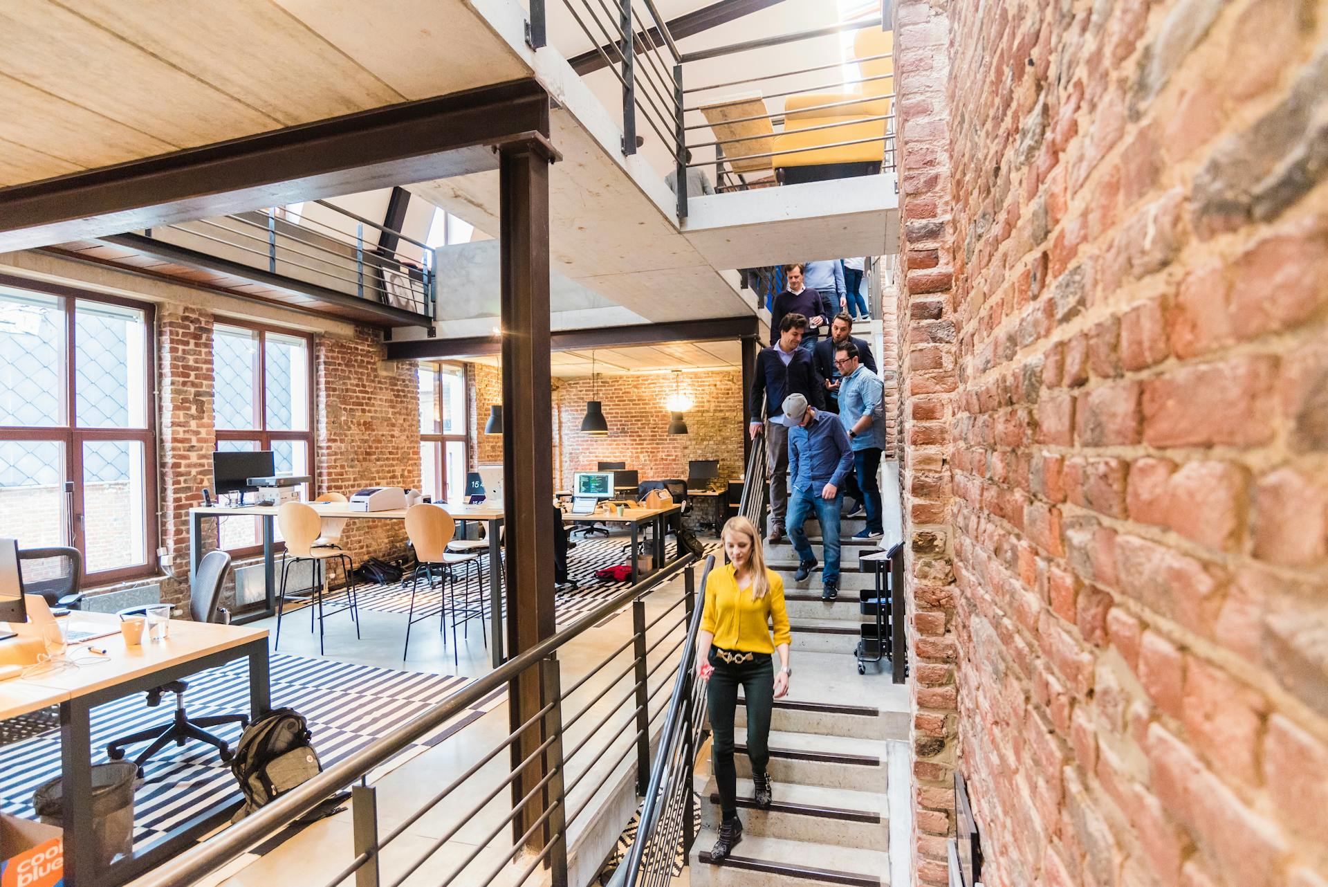 Gente bajando la escalera en un lugar de trabajo | Fuente: Pexels