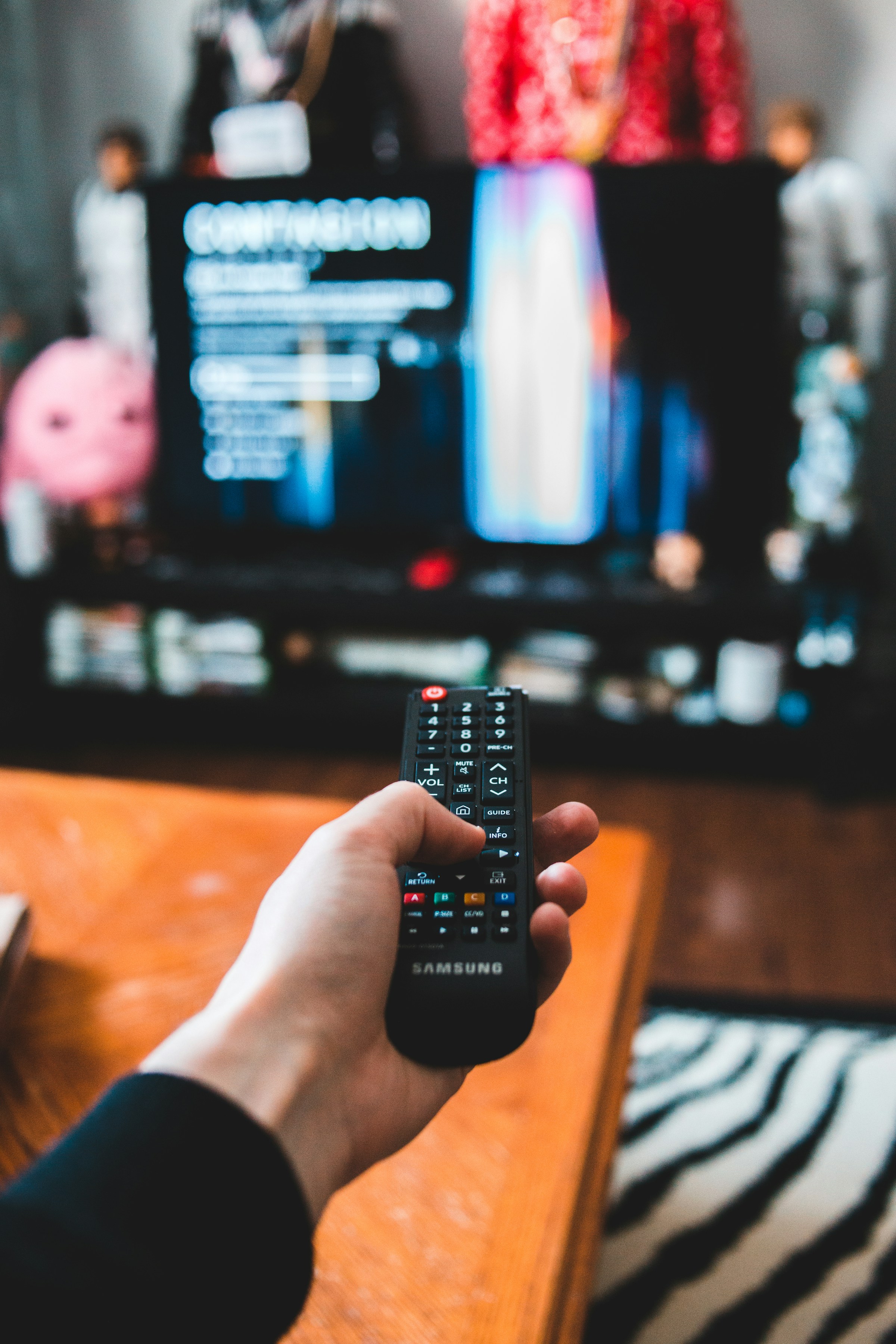 Una persona sujetando el mando a distancia de un televisor | Fuente: Unsplash