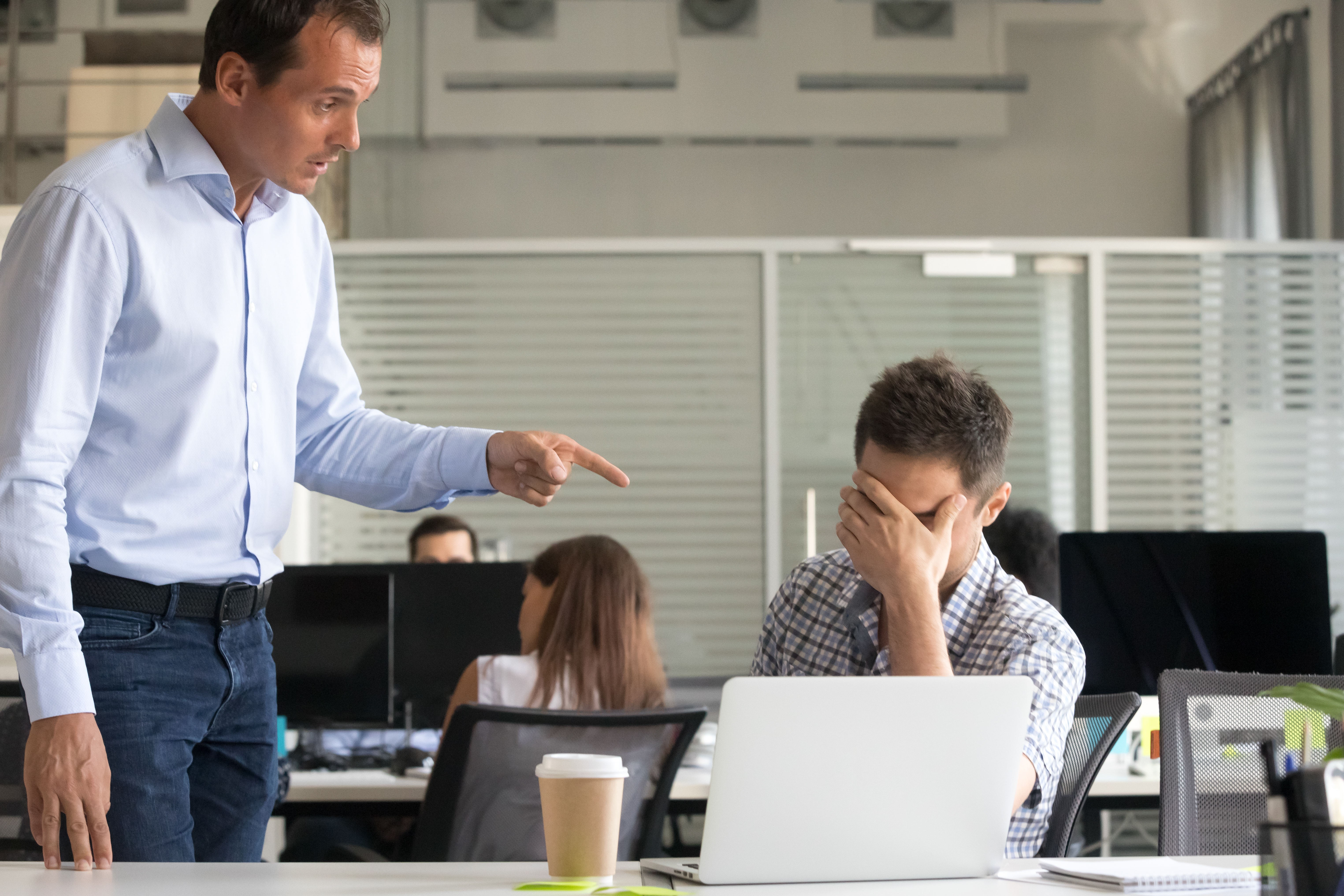 Un hombre regaña a otro en una oficina | Fuente: Shutterstock