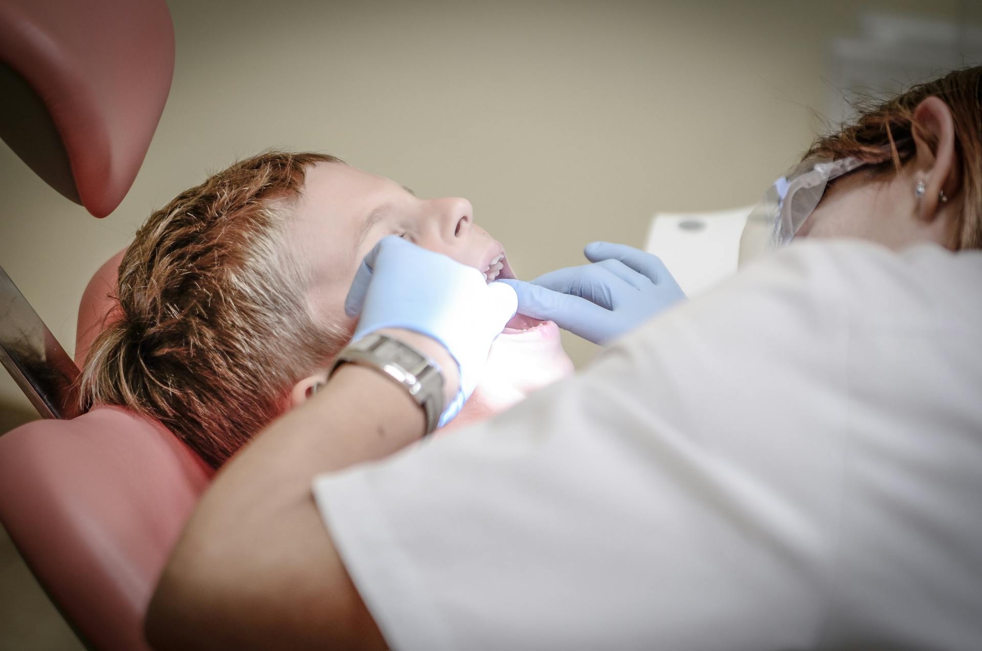 Un dentista revisando los dientes de un niño | Fuente: Pexels
