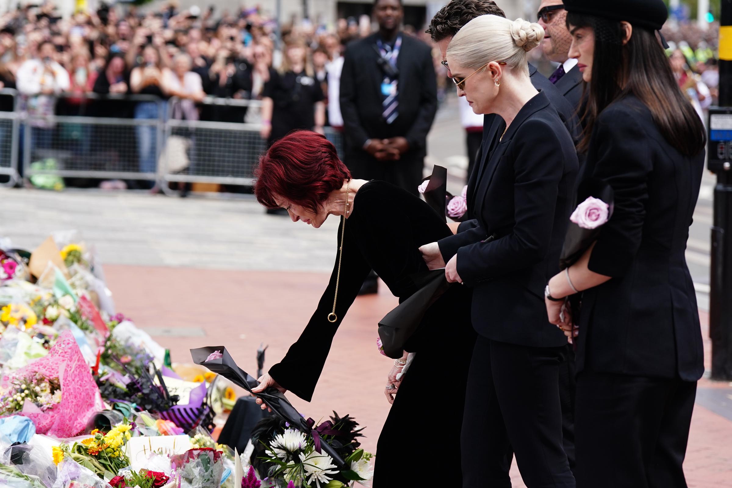 La familia Osbourne observa los mensajes y tributos florales dejados en el puente de Black Sabbath en Birmingham el 30 de julio de 2025 | Fuente: Getty Images