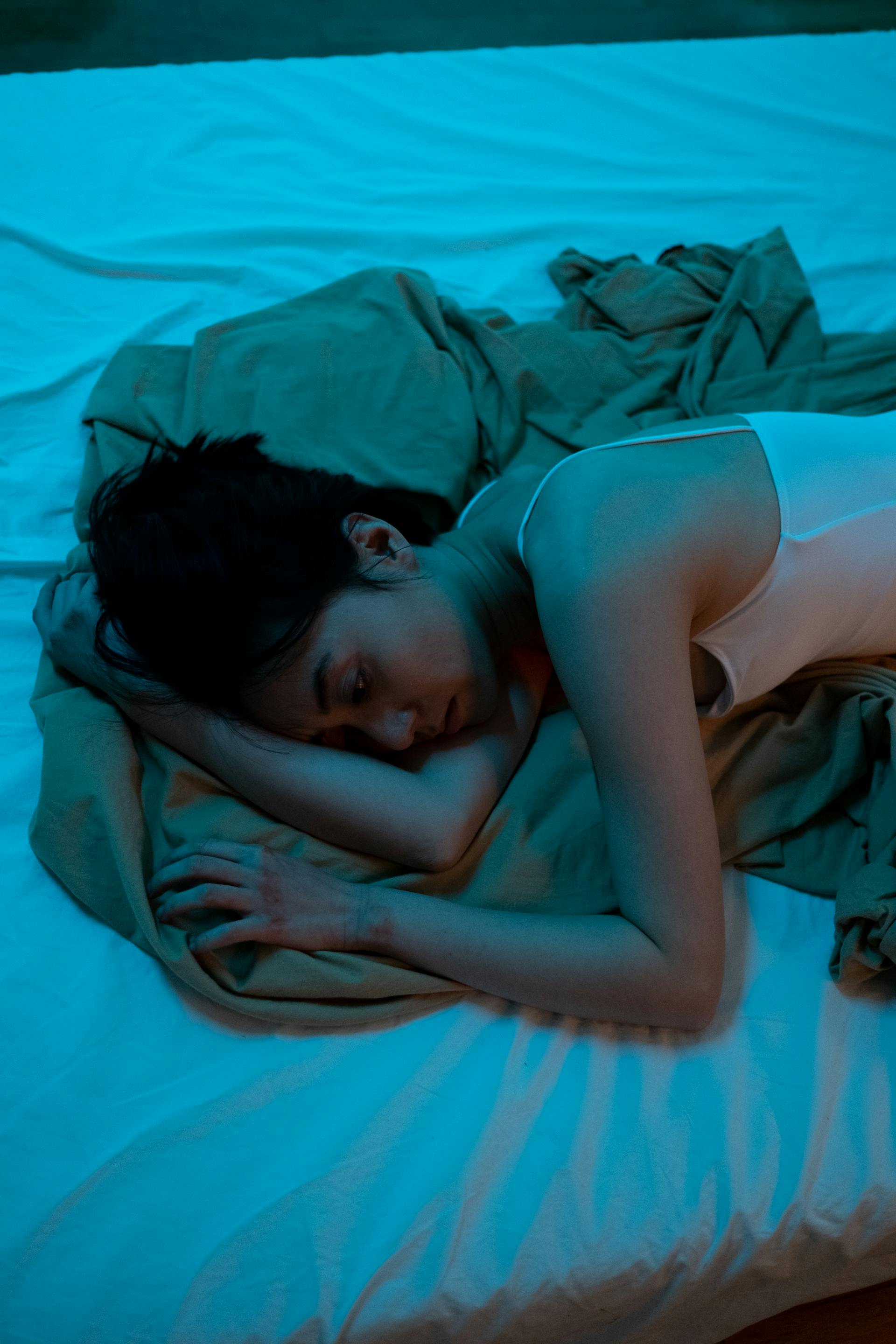 Una mujer triste tumbada en una cama | Fuente: Pexels