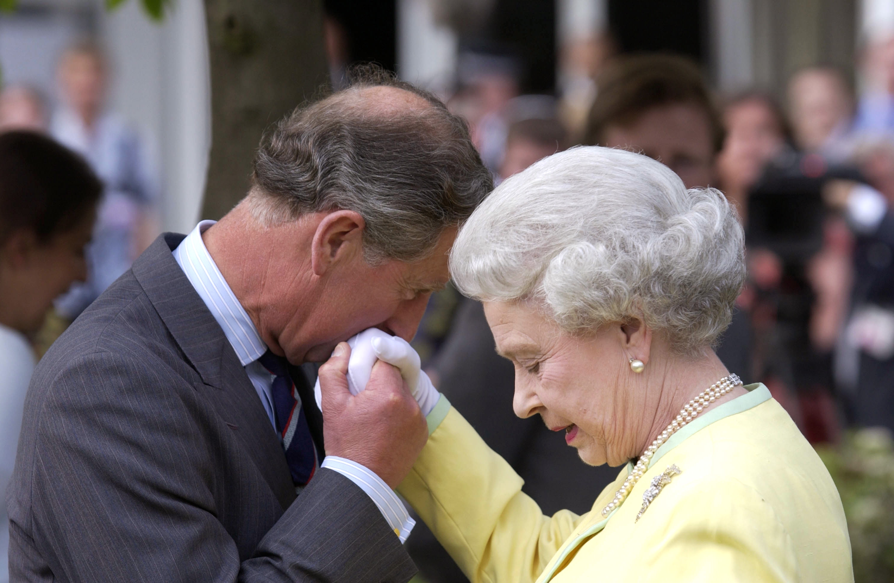 Rey Charles III, antiguo Príncipe de Gales, besando la mano de la reina Elizabeth II en la Exposición Floral de Chelsea en 2002 | Foto: Getty Images