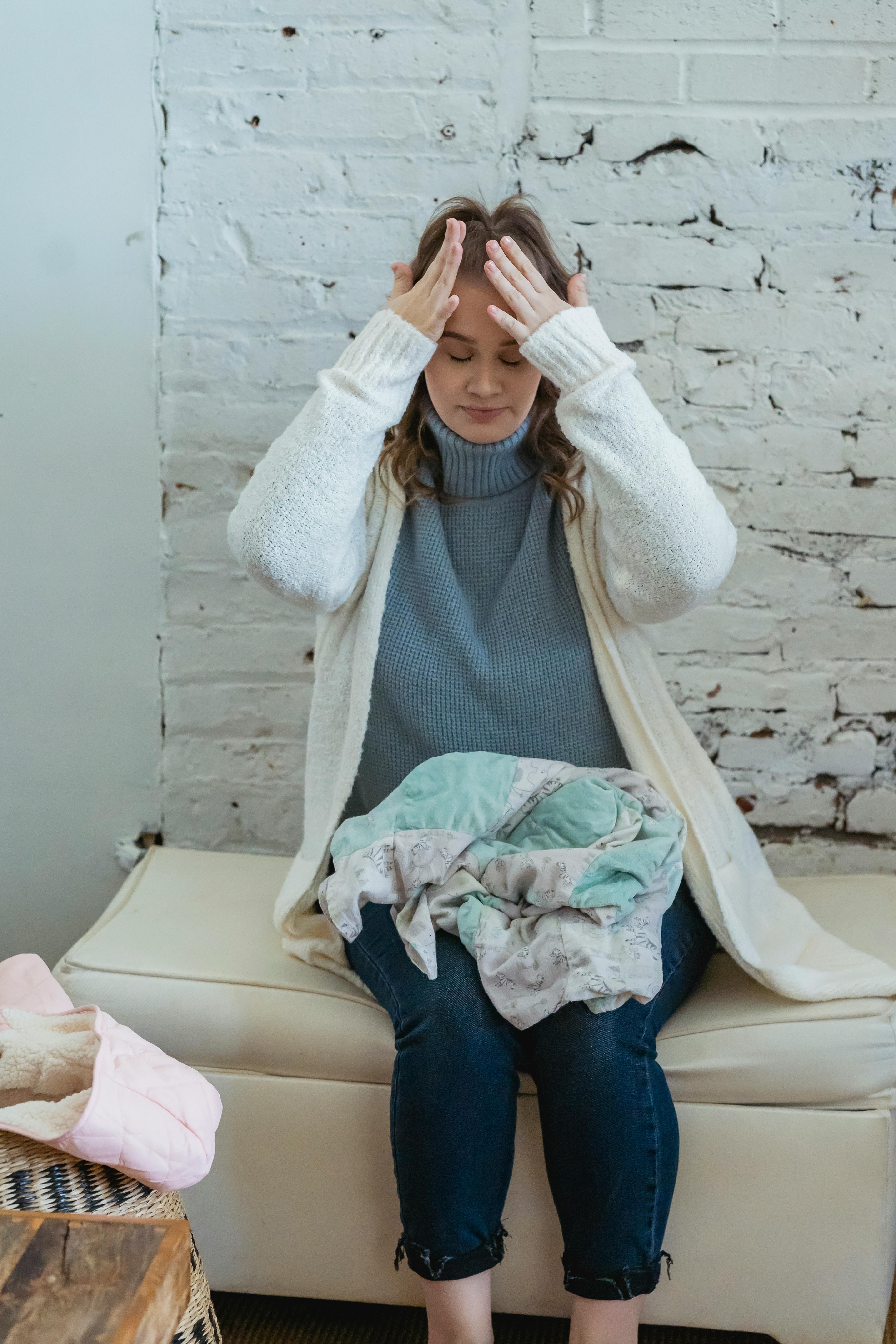 Mujer frotándose la frente con las manos en señal de frustración | Fuente: Pexels