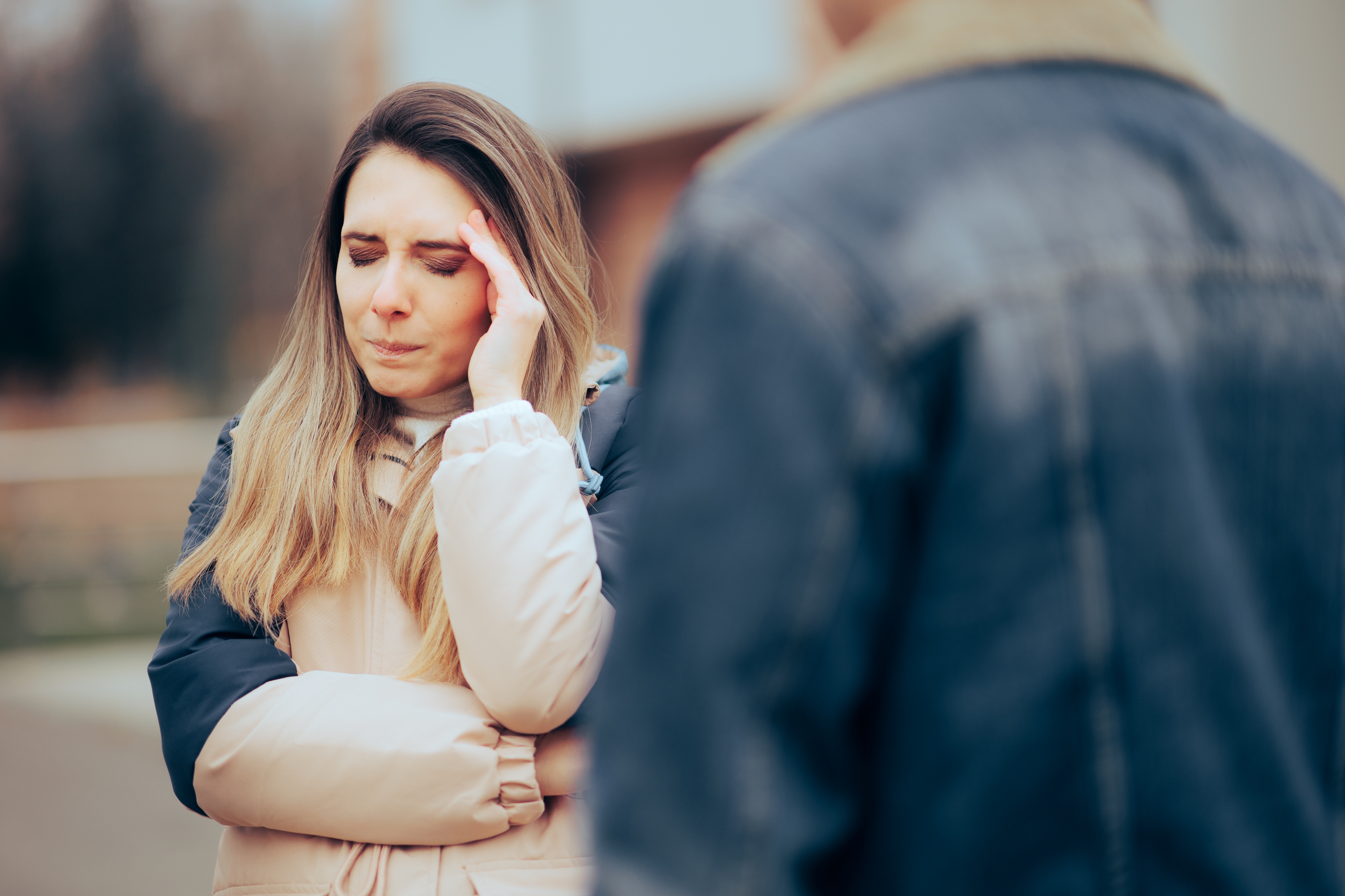 Una mujer de pie con la mano en la cara | Fuente: Shutterstock