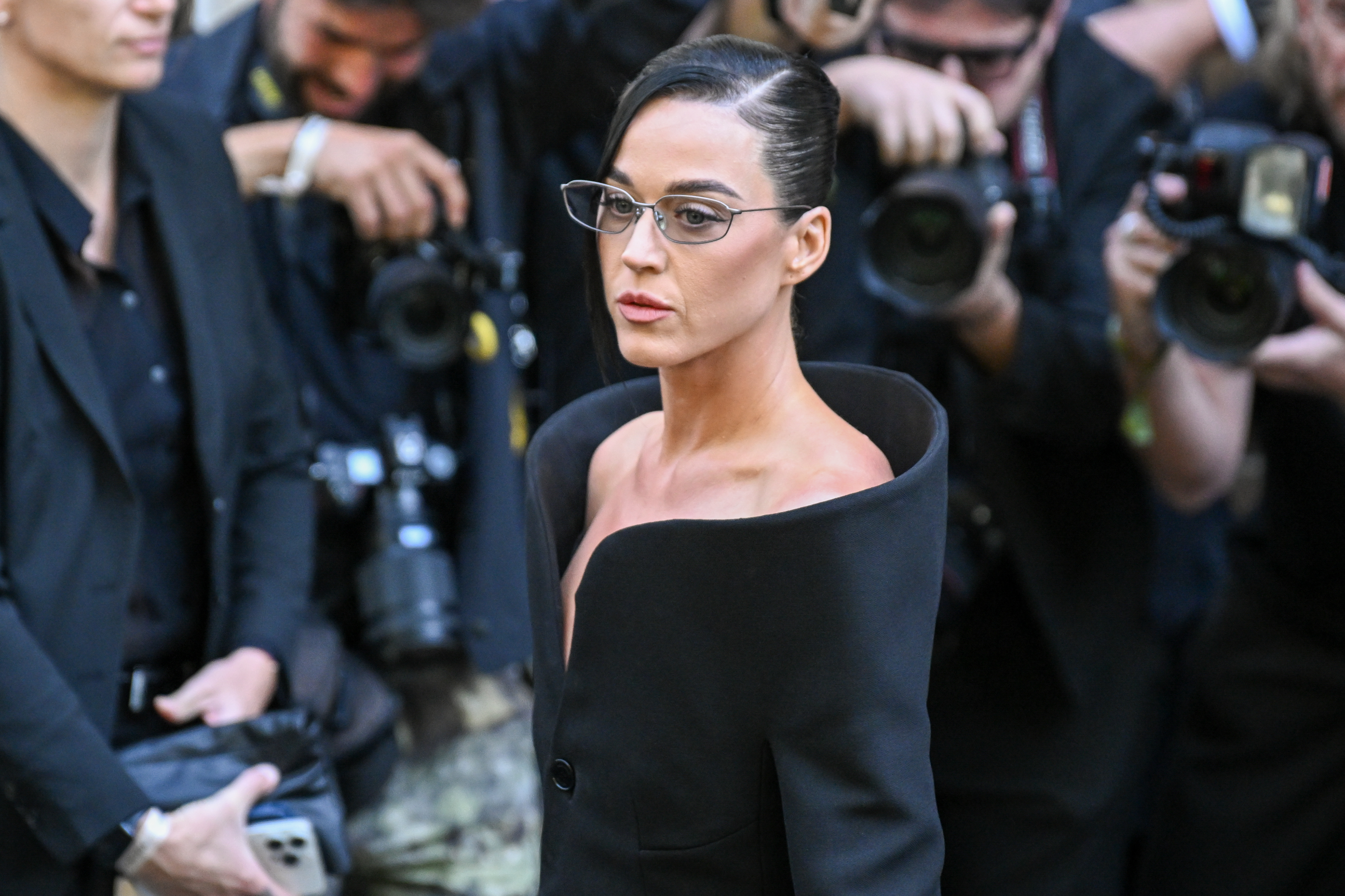 La batalla legal por la mansión de Perry en Montecito siguió adelante incluso después de que un juez confirmara el contrato de compraventa. La cantante, a la que se ve en la foto con un vestido negro con hombros al aire en la Semana de la Moda de París el 9 de julio de 2025, siguió involucrada en la disputa por los daños y perjuicios económicos. | Fuente: Getty Images