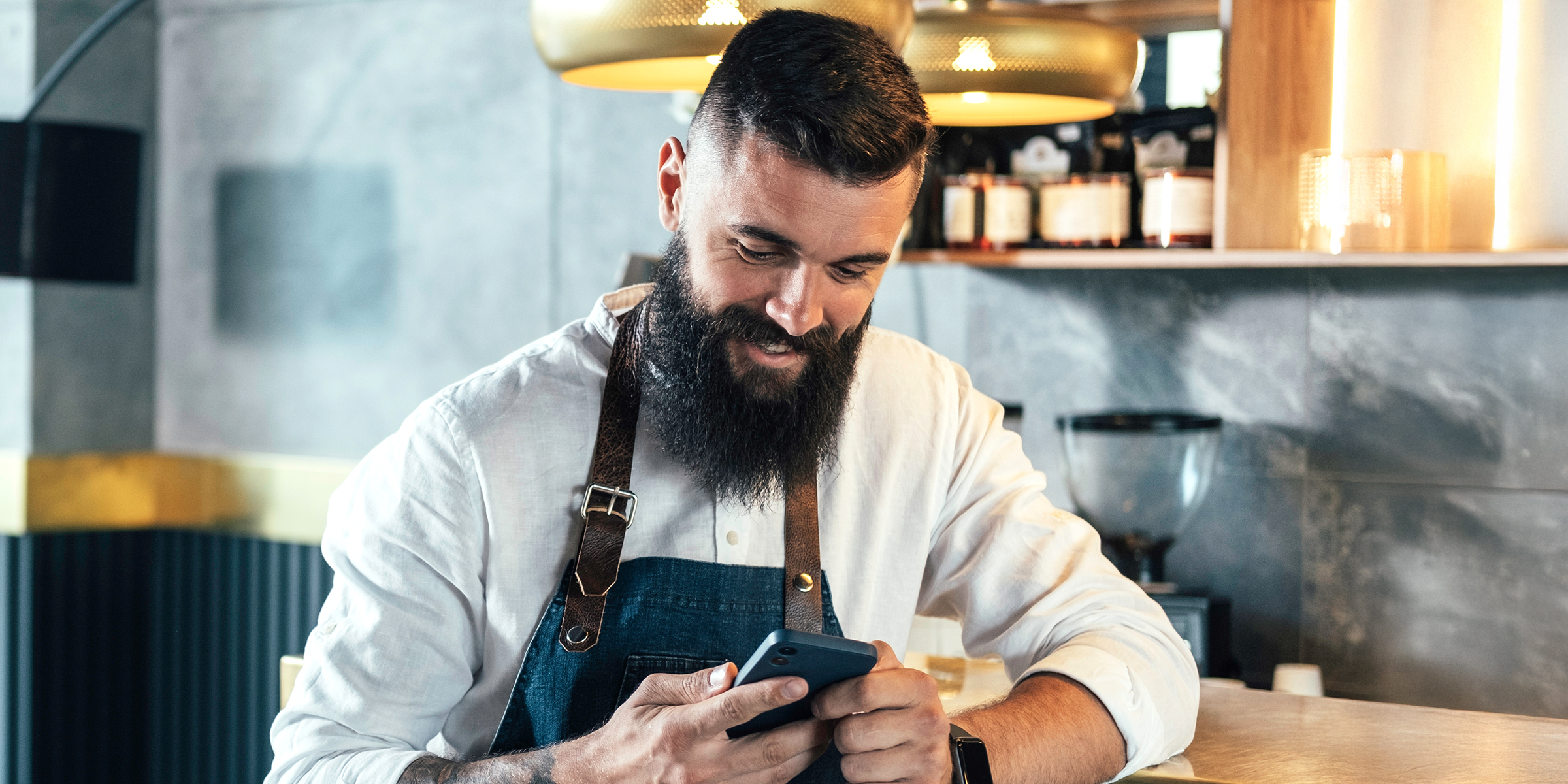 Un hombre mirando su teléfono y riéndose | Fuente: Shutterstock